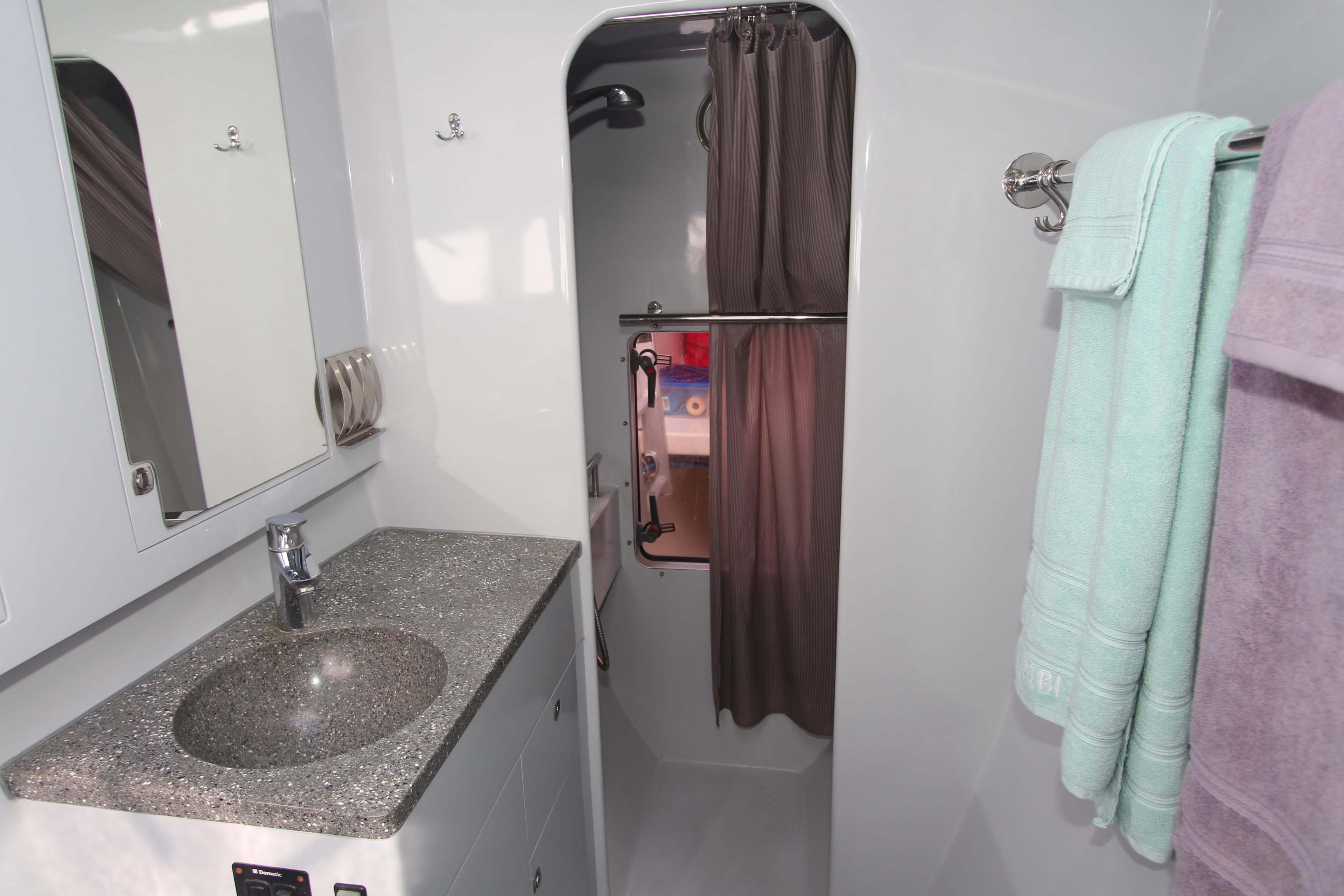 Modern yacht bathroom with granite sink, shower, and towels; Chris White Atlantic 49 MastFoil 2018.