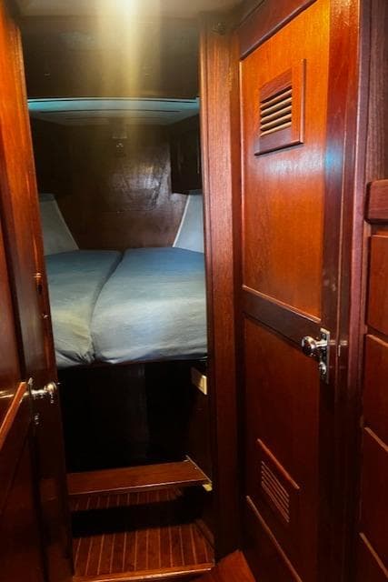 Cozy cabin interior of 1974 Spencer Yachts 1330 with wooden finish and bed.