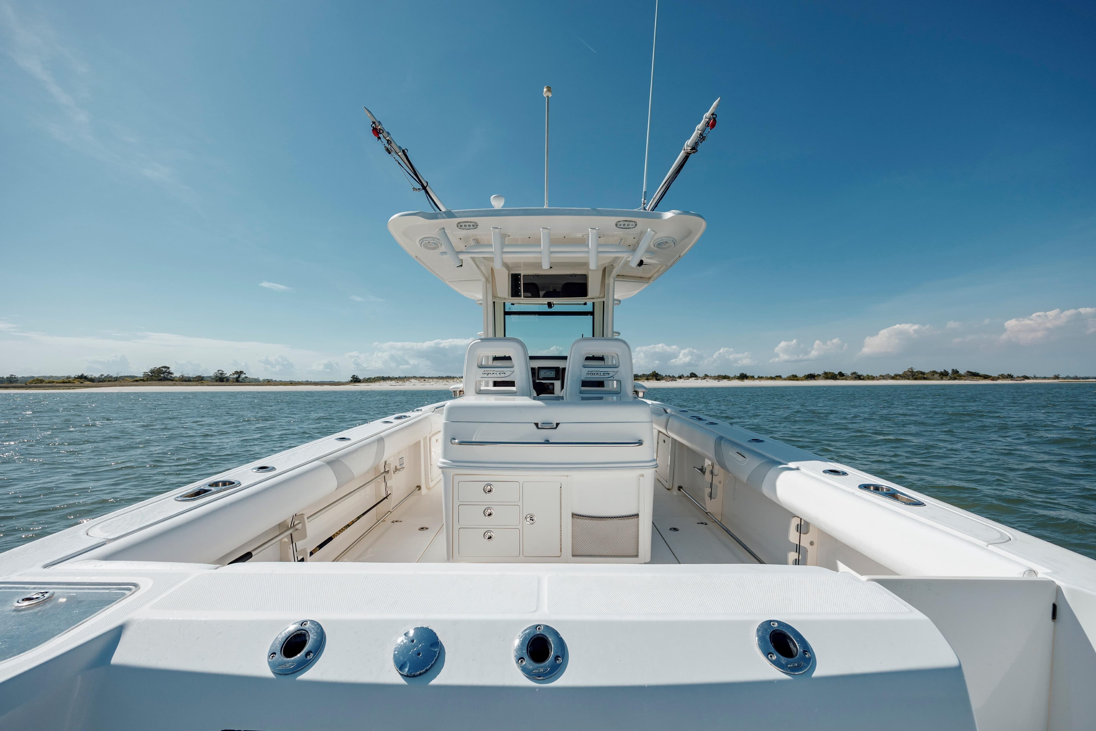 2013 Boston Whaler 320 Outrage boat on calm water under clear blue sky.