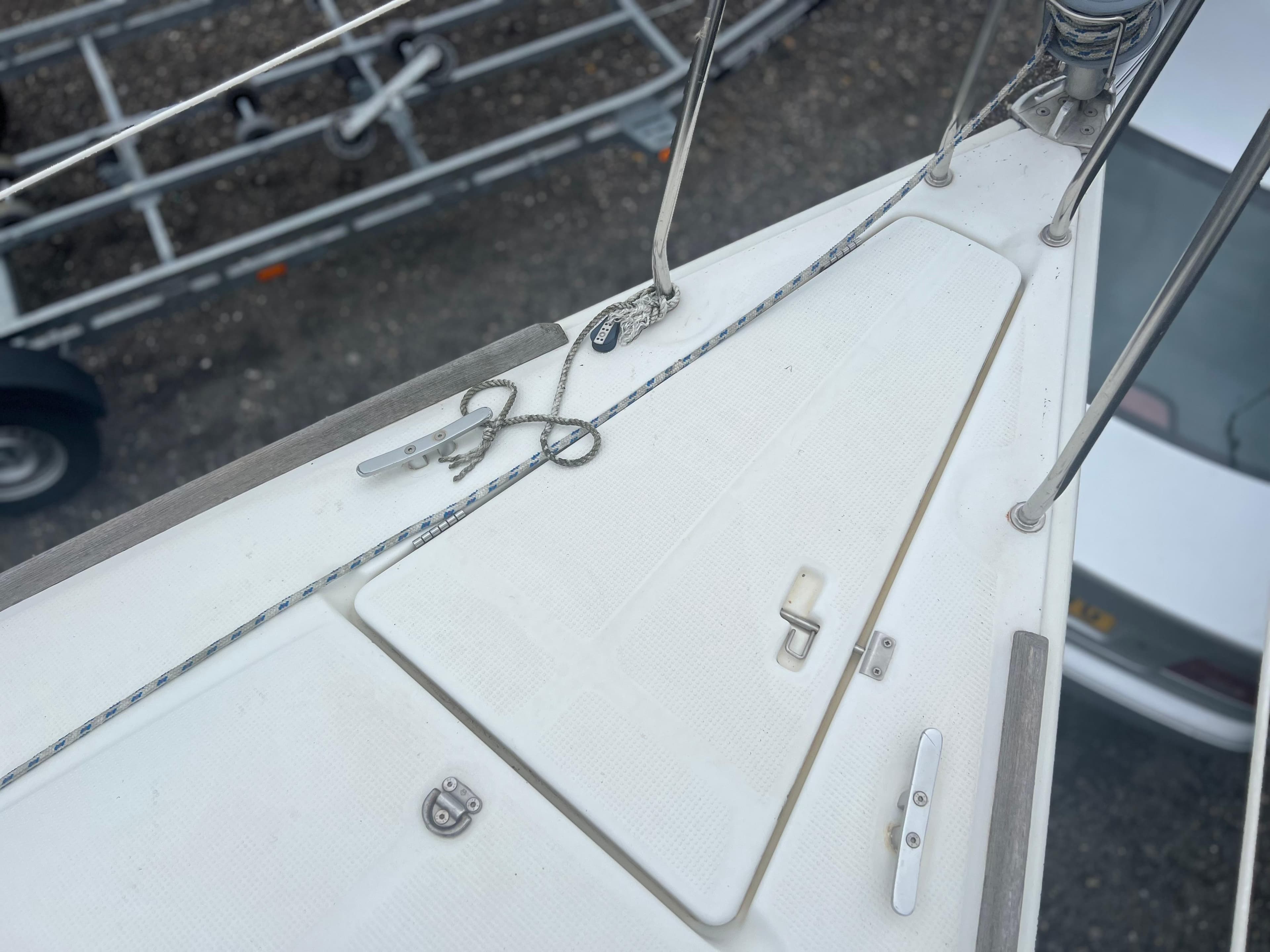 Bow of a 2004 Beneteau First 211 sailboat with deck fittings and ropes.