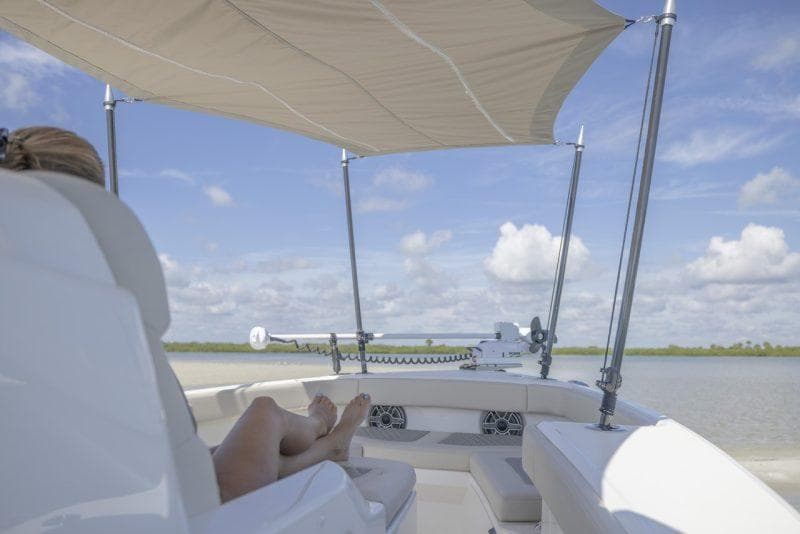 Manufacturer Provided Image: 2026 Solace 30 HCS boat with canopy, person relaxing, scenic water view.