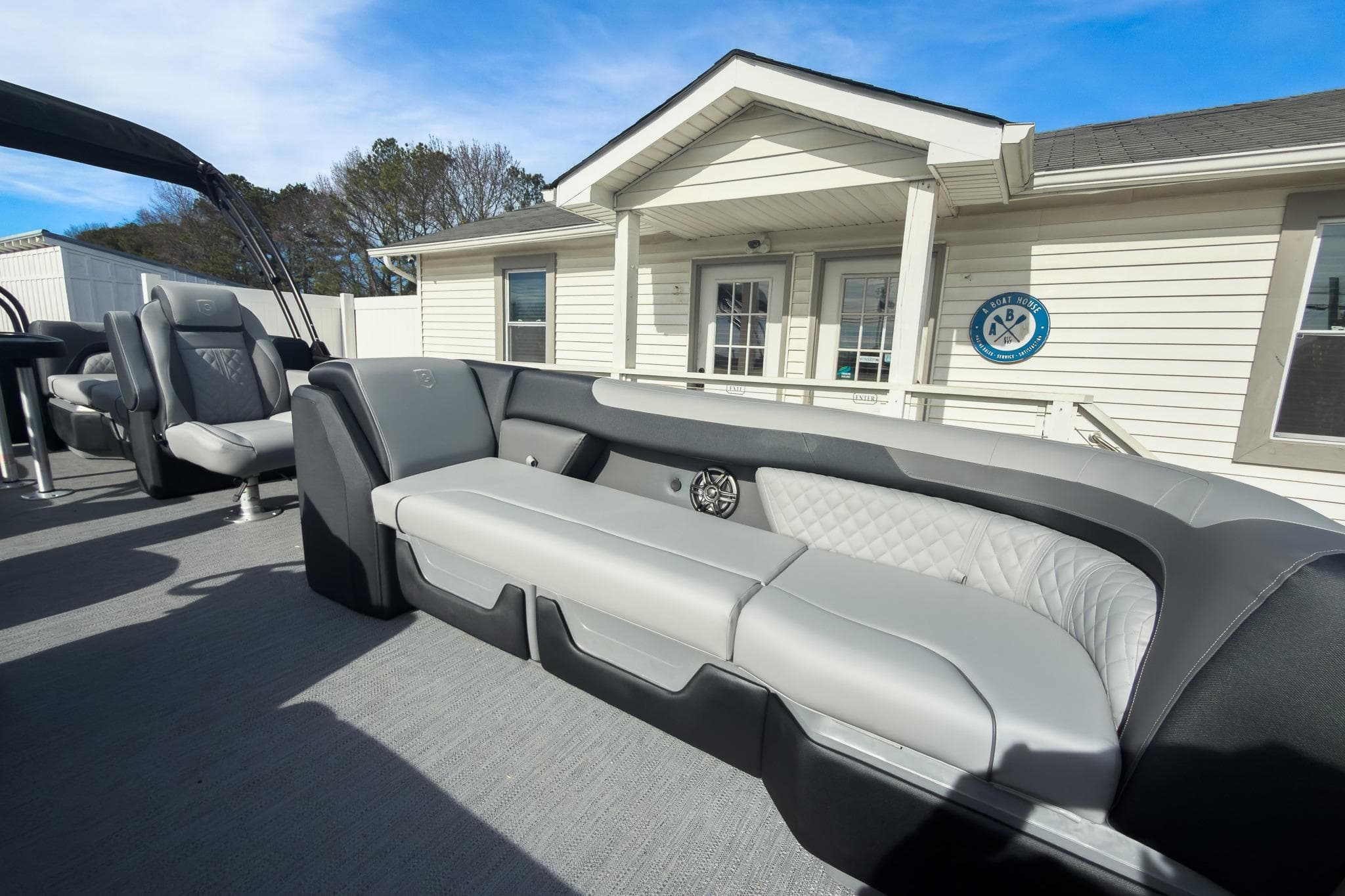 2026 Godfrey Sweetwater 22' Tritoon with split bench seating, docked near a building.