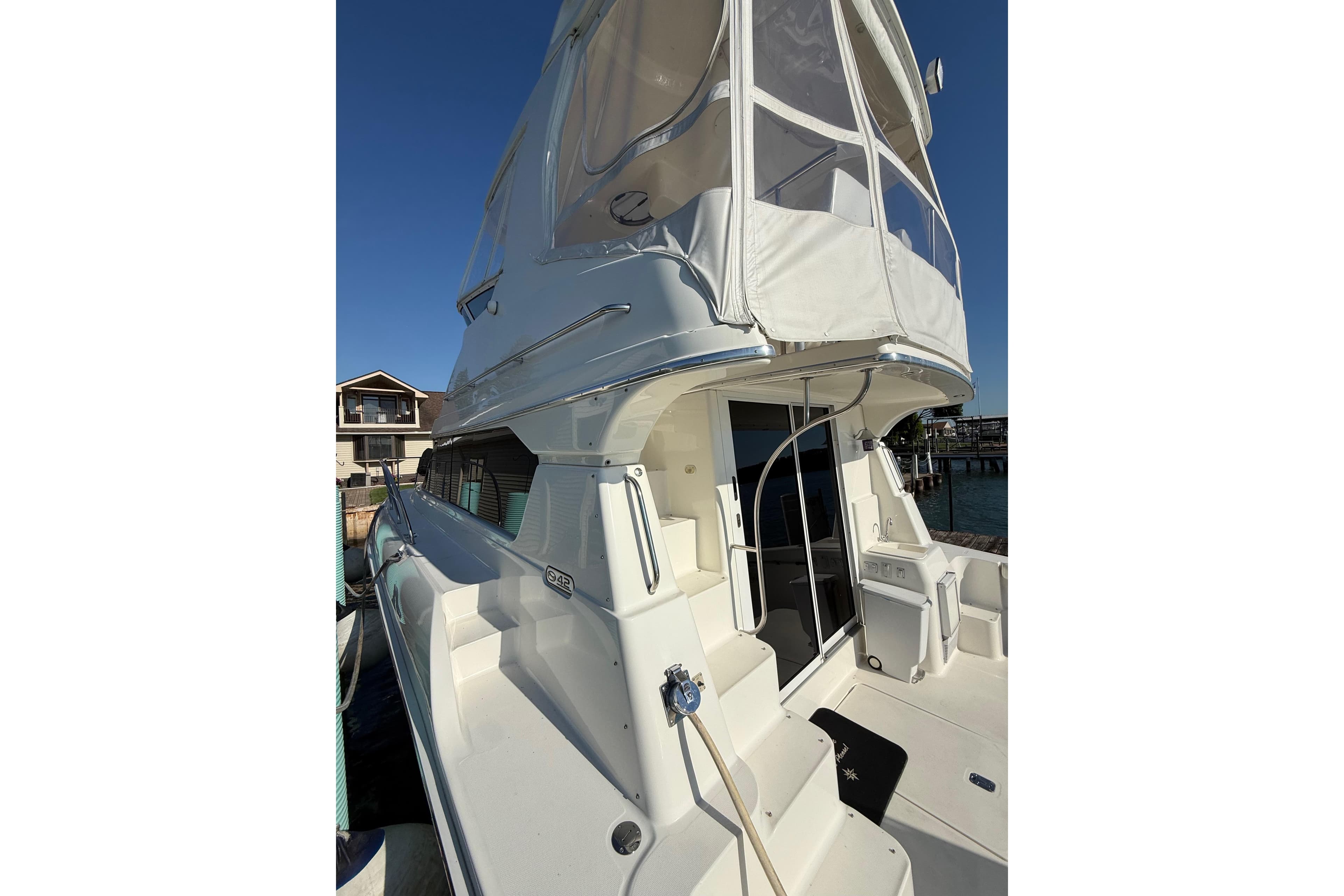 2001 Silverton 42 Convertible yacht docked, featuring spacious deck and flybridge enclosure.