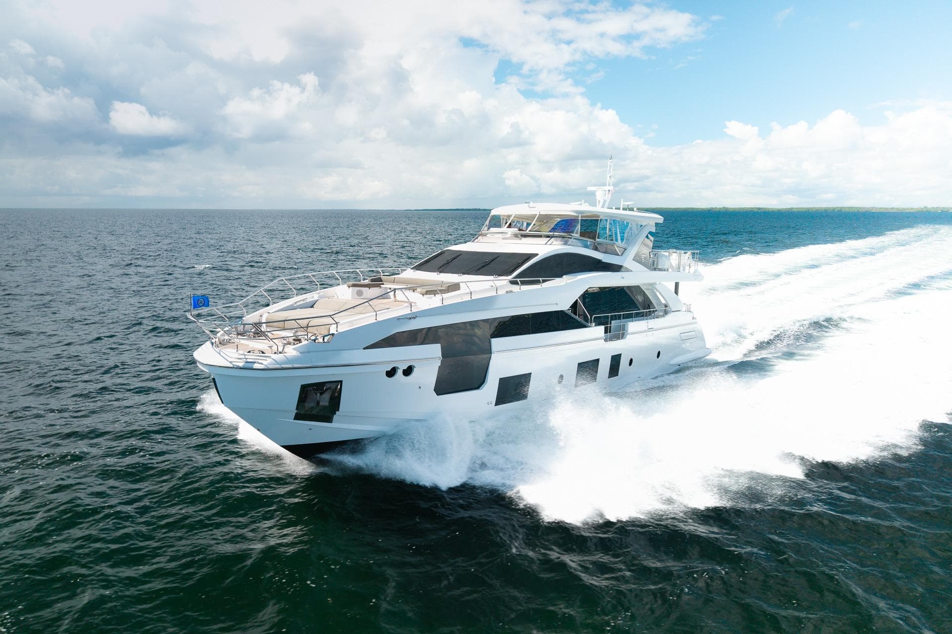 Luxurious 2022 Azimut Grande 27 METRI yacht cruising on open sea under clear skies.
