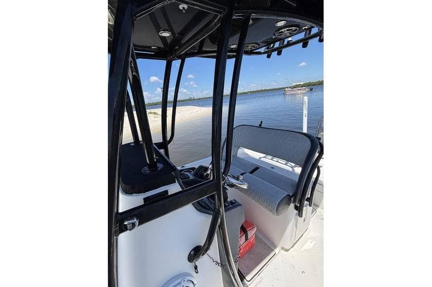 2018 ShearWater 25 LTD boat interior with seating, near sandy shore and calm water.