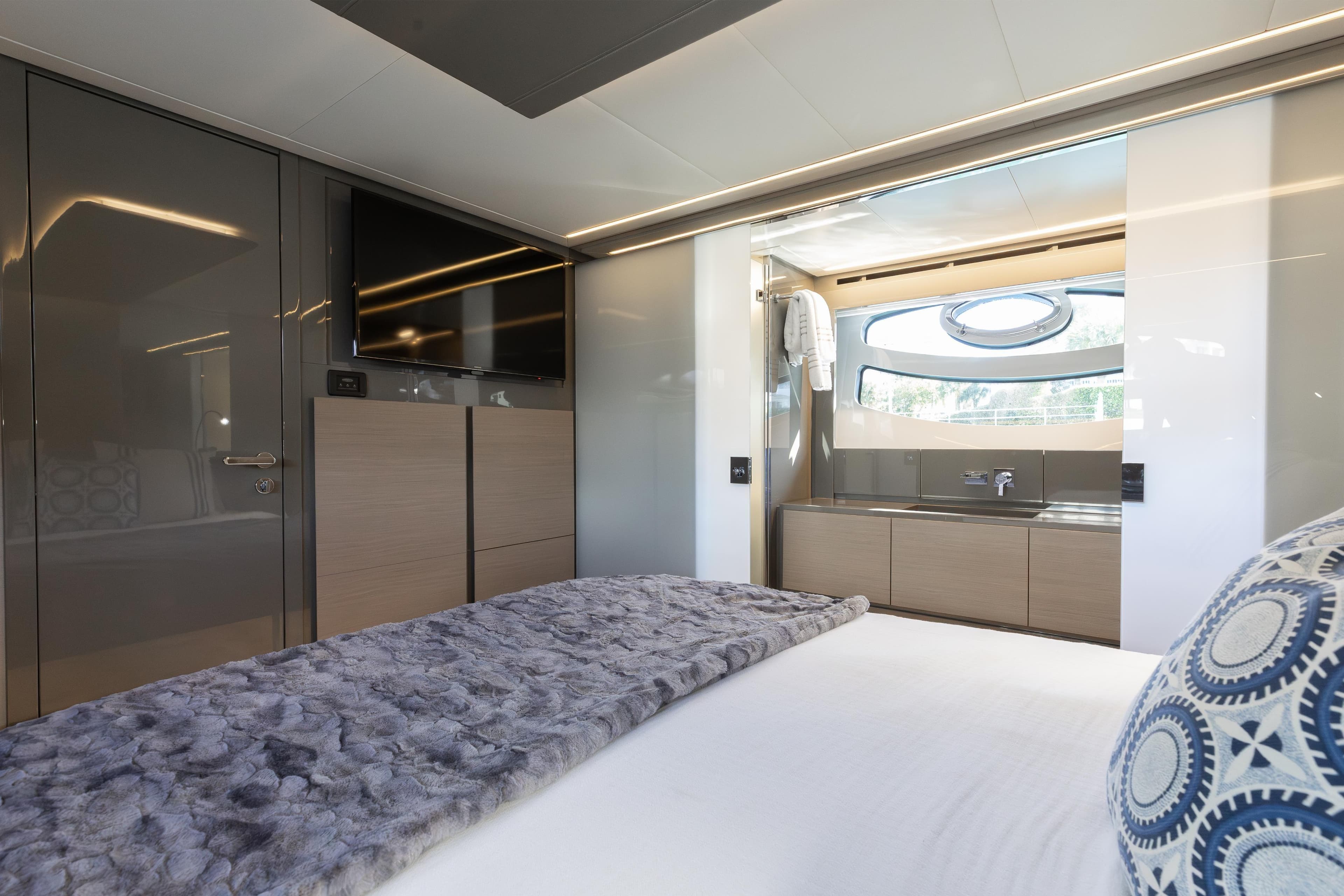Luxurious interior of 2016 Pershing 62 yacht with modern bedroom and ensuite bathroom.