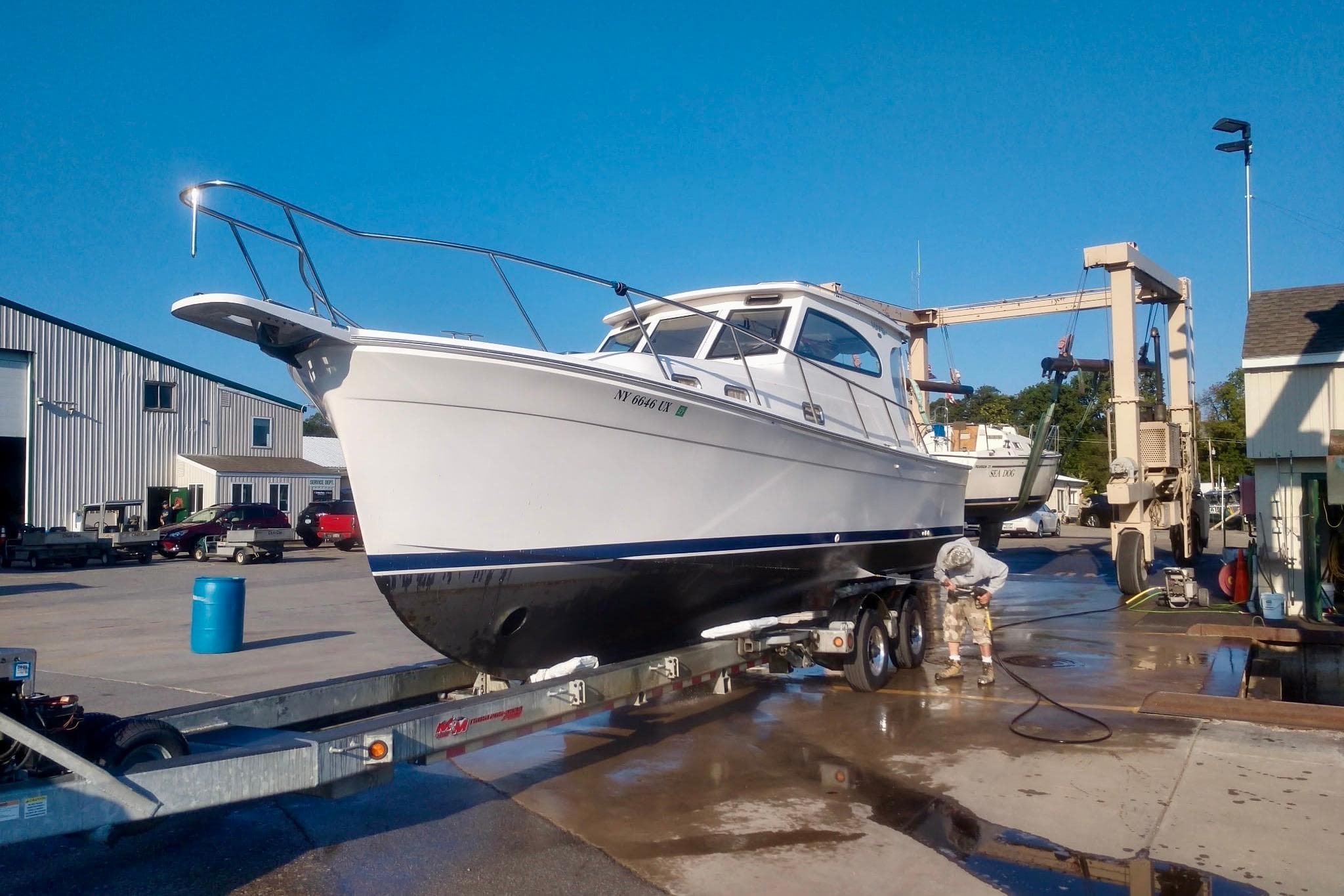 2003 Mainship Pilot 30-II boat on trailer at marina, undergoing maintenance.