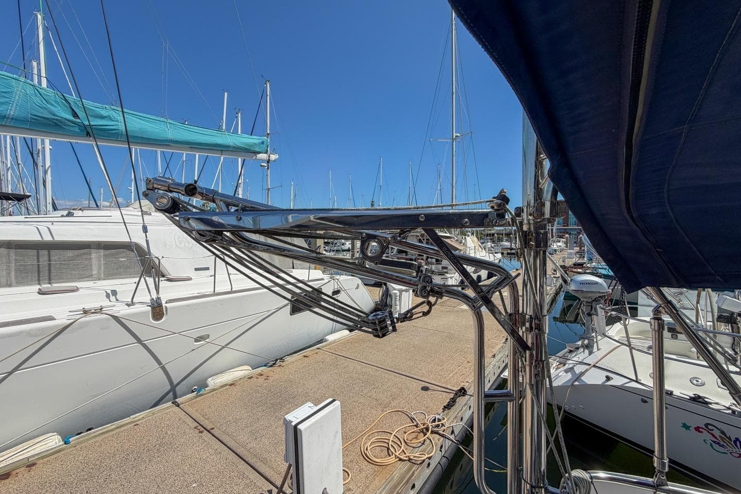 Sailboat docked at marina, featuring Catalina 42, 1993 model, with clear blue sky.