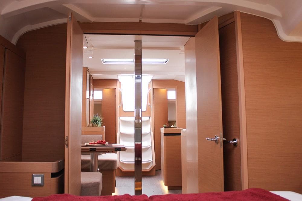 Interior of 2025 Jeanneau Sun Odyssey 440 yacht, featuring modern wood finish and cozy seating.