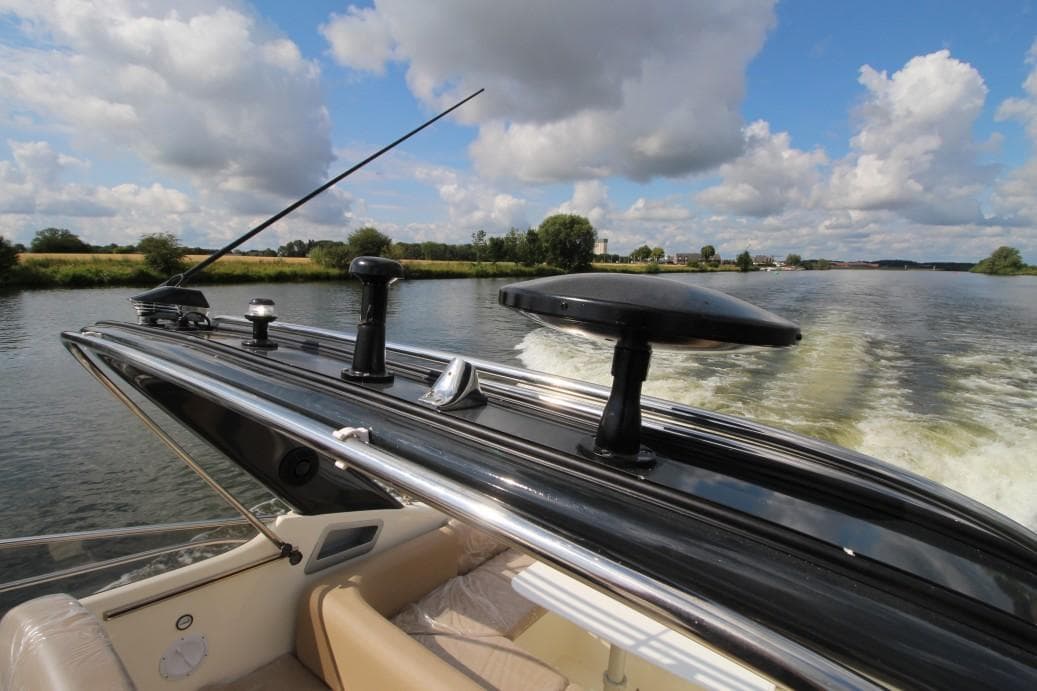 Airon Marine 325 boat cruising on a river, 2003 model, under a partly cloudy sky.