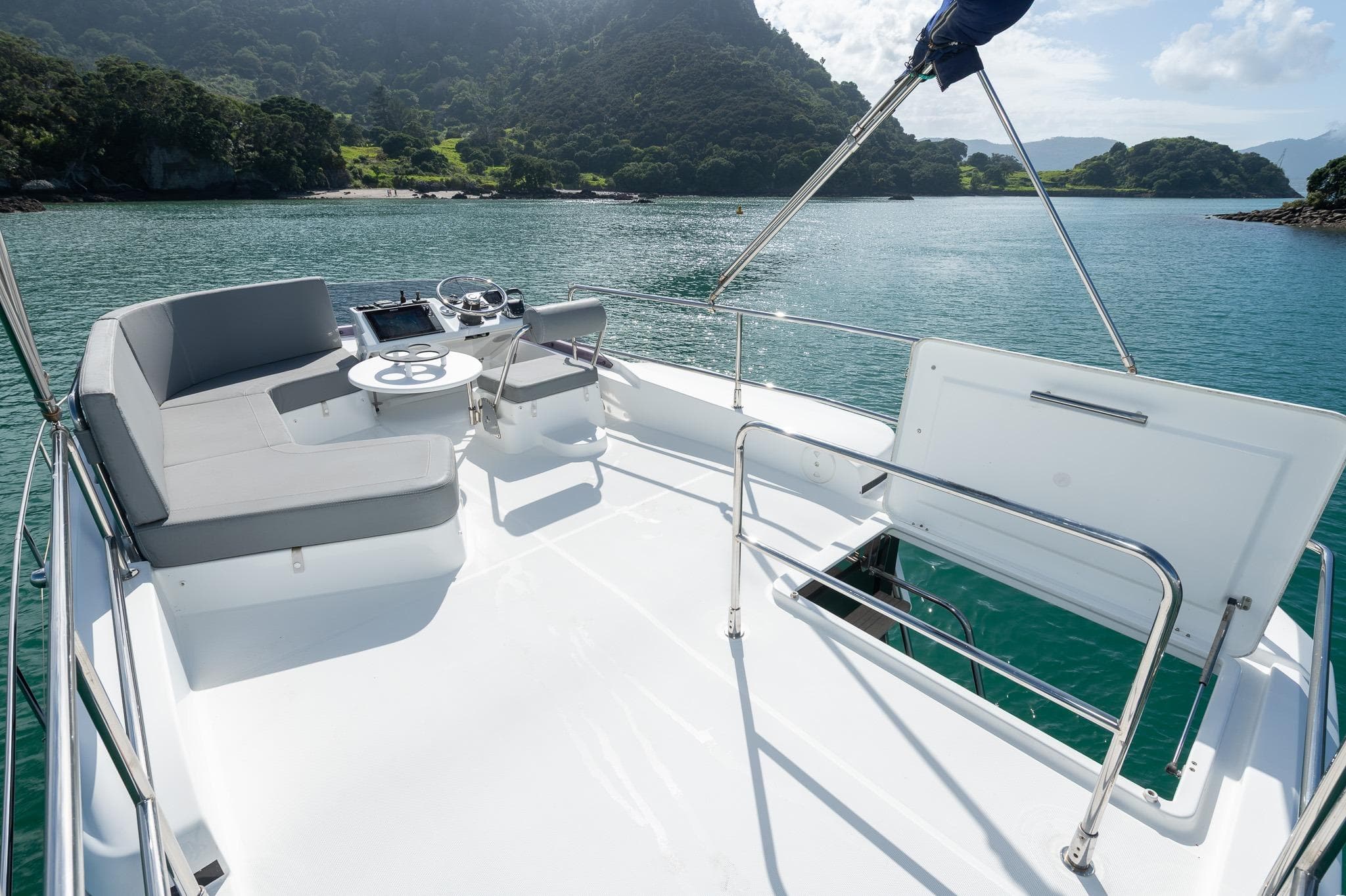 2018 Beneteau Swift Trawler 30 flybridge with seating, overlooking scenic coastal waters.