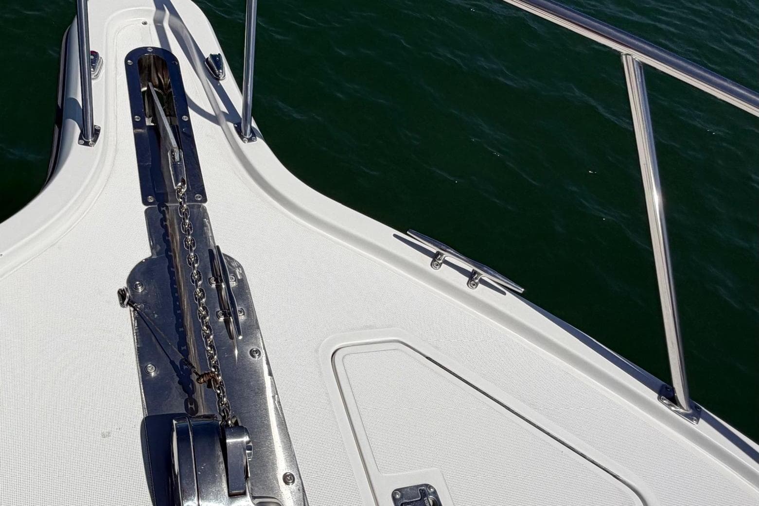 Bow of 1999 Tiara Yachts 4100 Open, featuring anchor chain and railing over water.