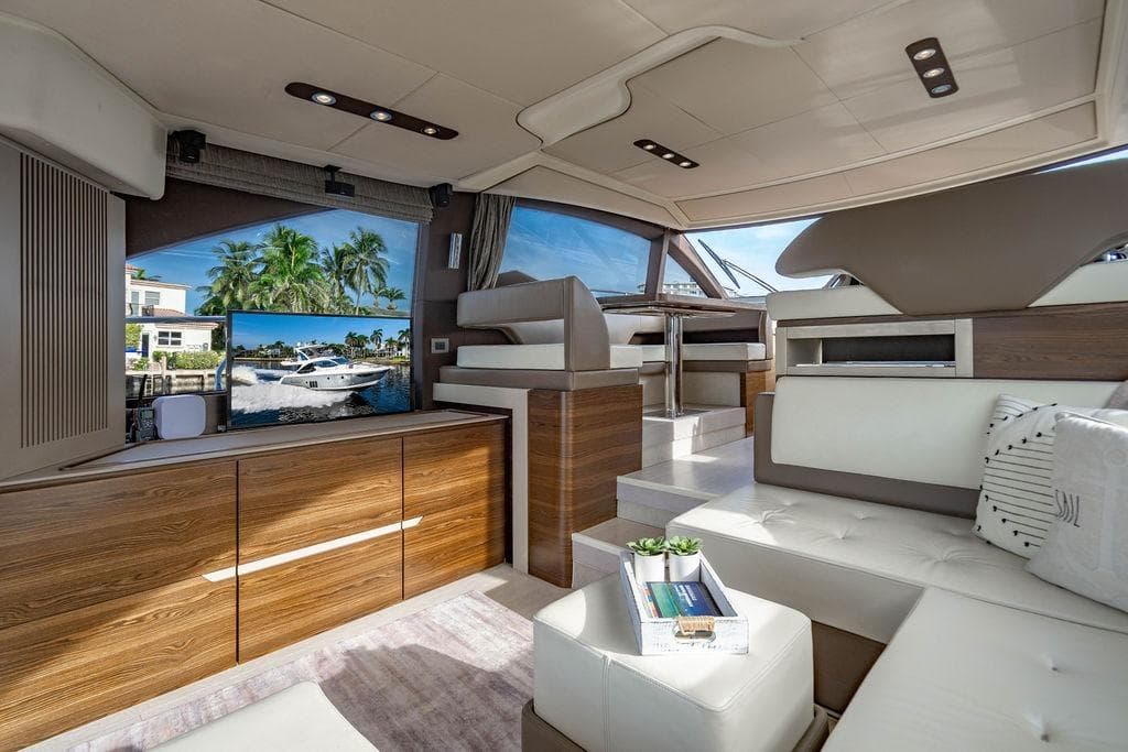 Luxurious interior of 2015 Azimut Fly 50 yacht with modern furnishings and scenic window view.