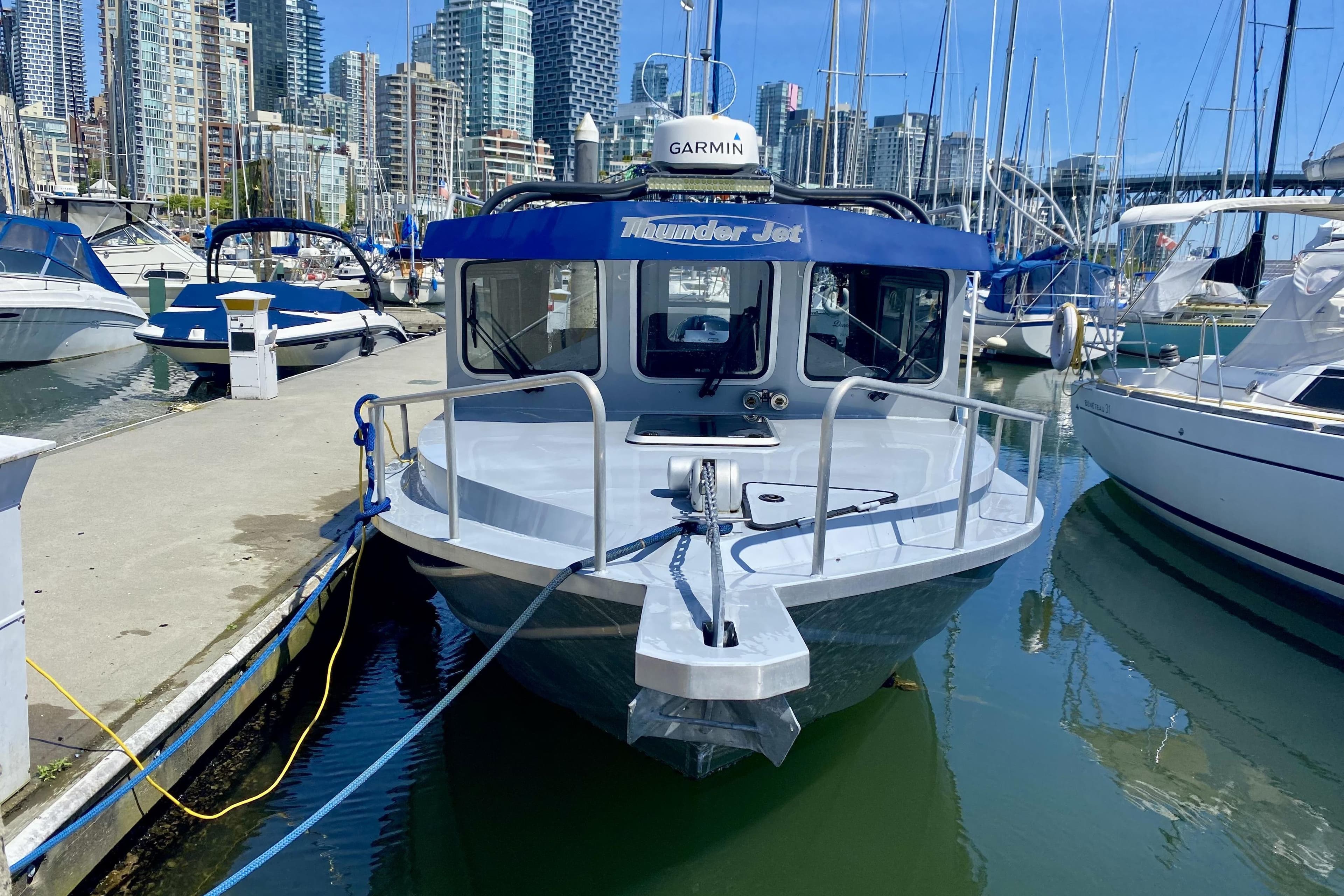 2017 Thunder Jet Pilot 24 boat docked in a marina with city skyline backdrop.
