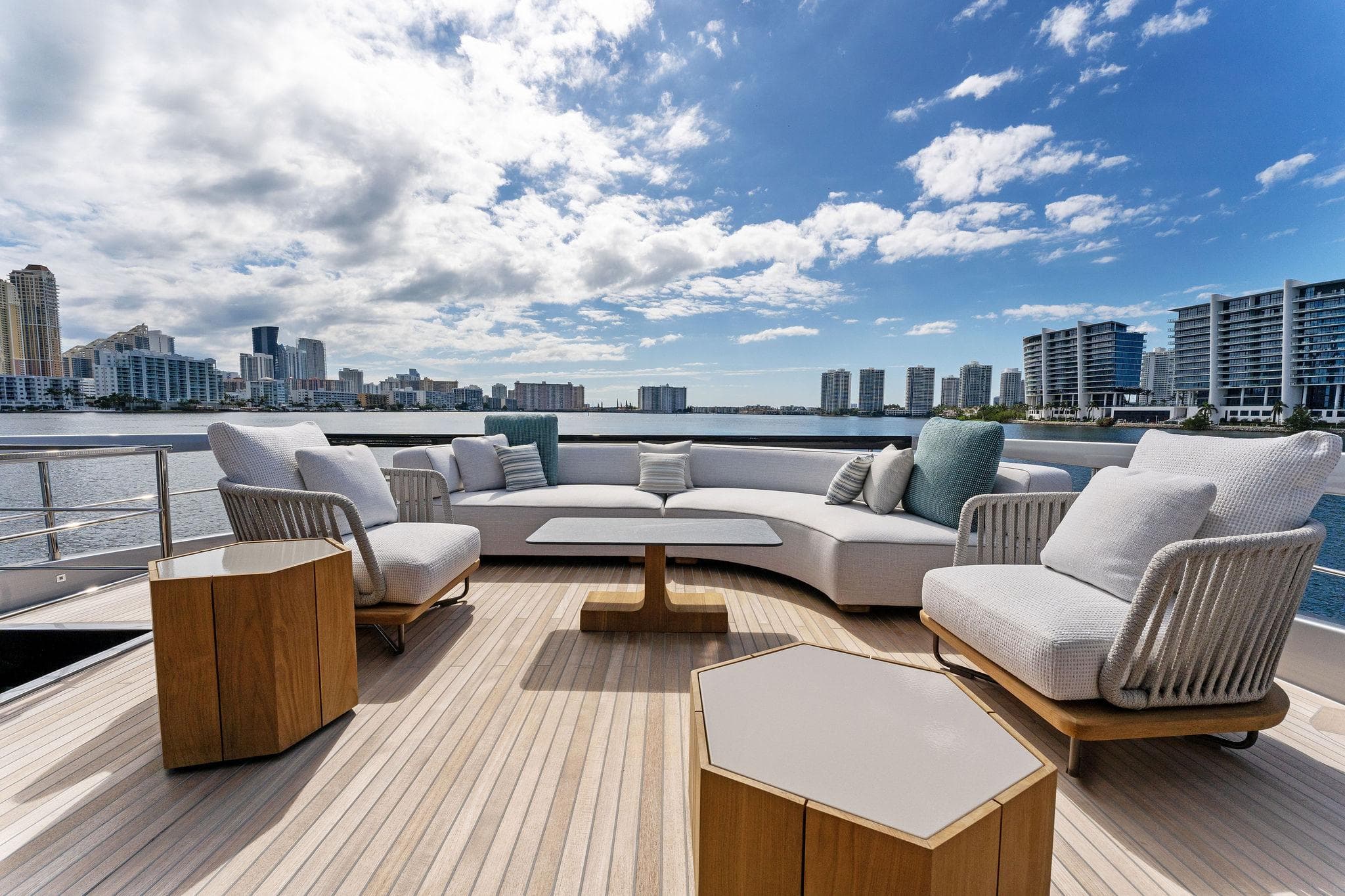 Luxurious deck of 2024 Riva 102 Corsaro Super yacht with modern seating and city skyline view.