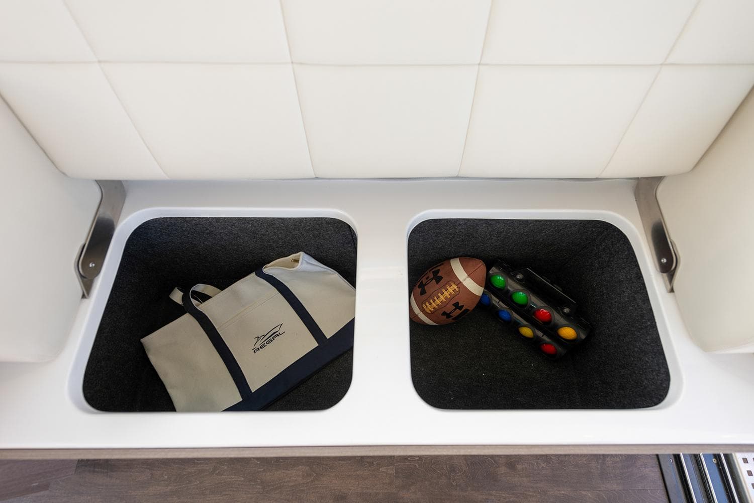 Manufacturer Provided Image: Storage compartments on a 2025 Regal 38 FXO boat with bag and sports items.