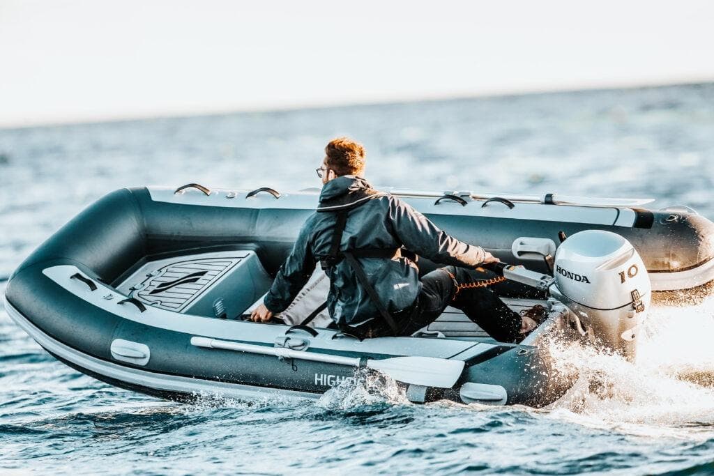 Man driving 2026 Highfield Classic 360 inflatable boat with Honda engine.