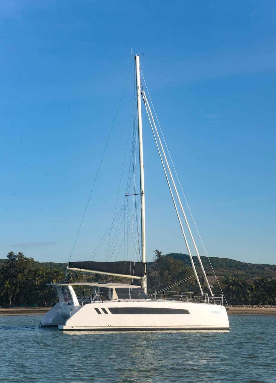 2025 Seawind 1170 catamaran sailing on calm waters under a clear blue sky.
