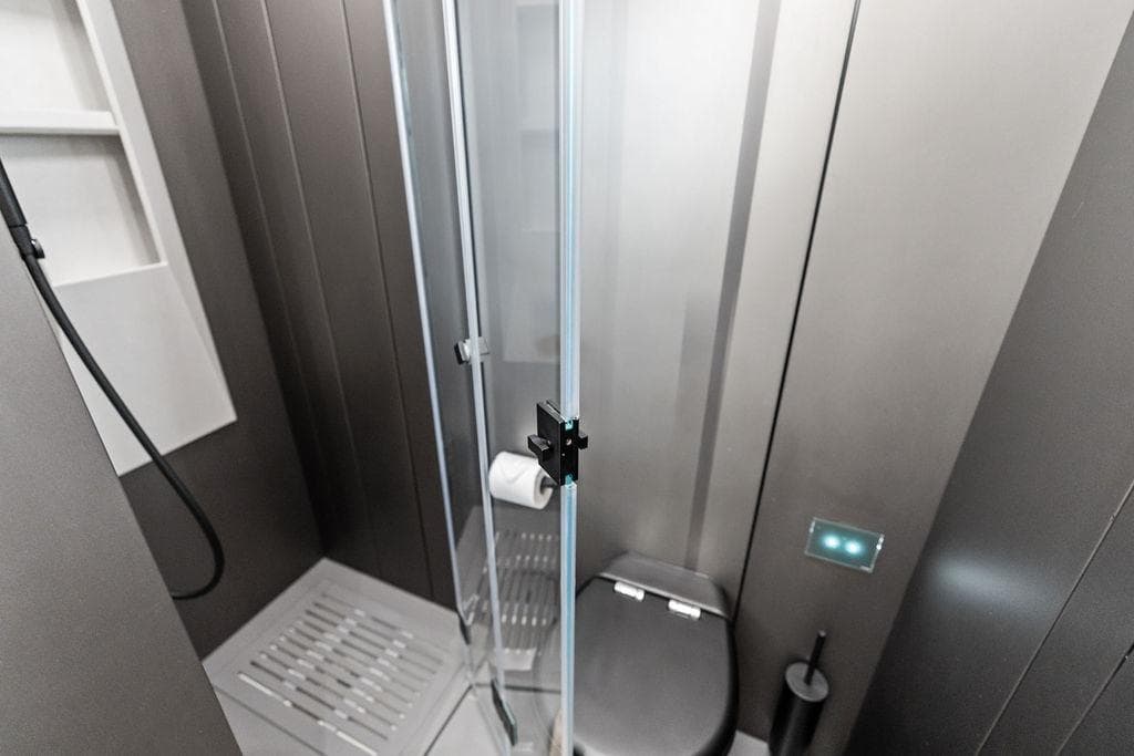 Modern bathroom in 2025 Pershing GTX 80 yacht with sleek shower and toilet.