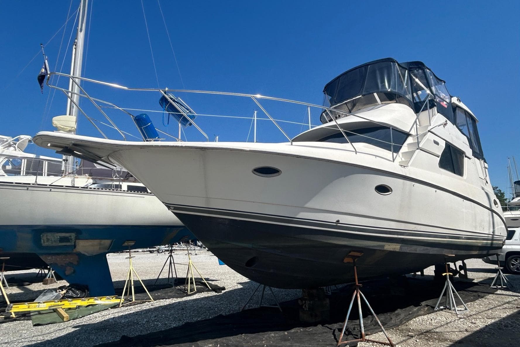 2000 Silverton 352 Motor Yacht on stands, displayed outdoors under clear blue sky.