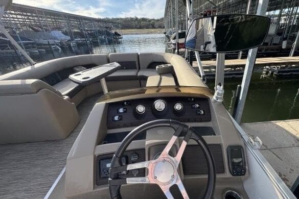 2021 Bennington L 24 Swingback boat interior with steering wheel and seating area.
