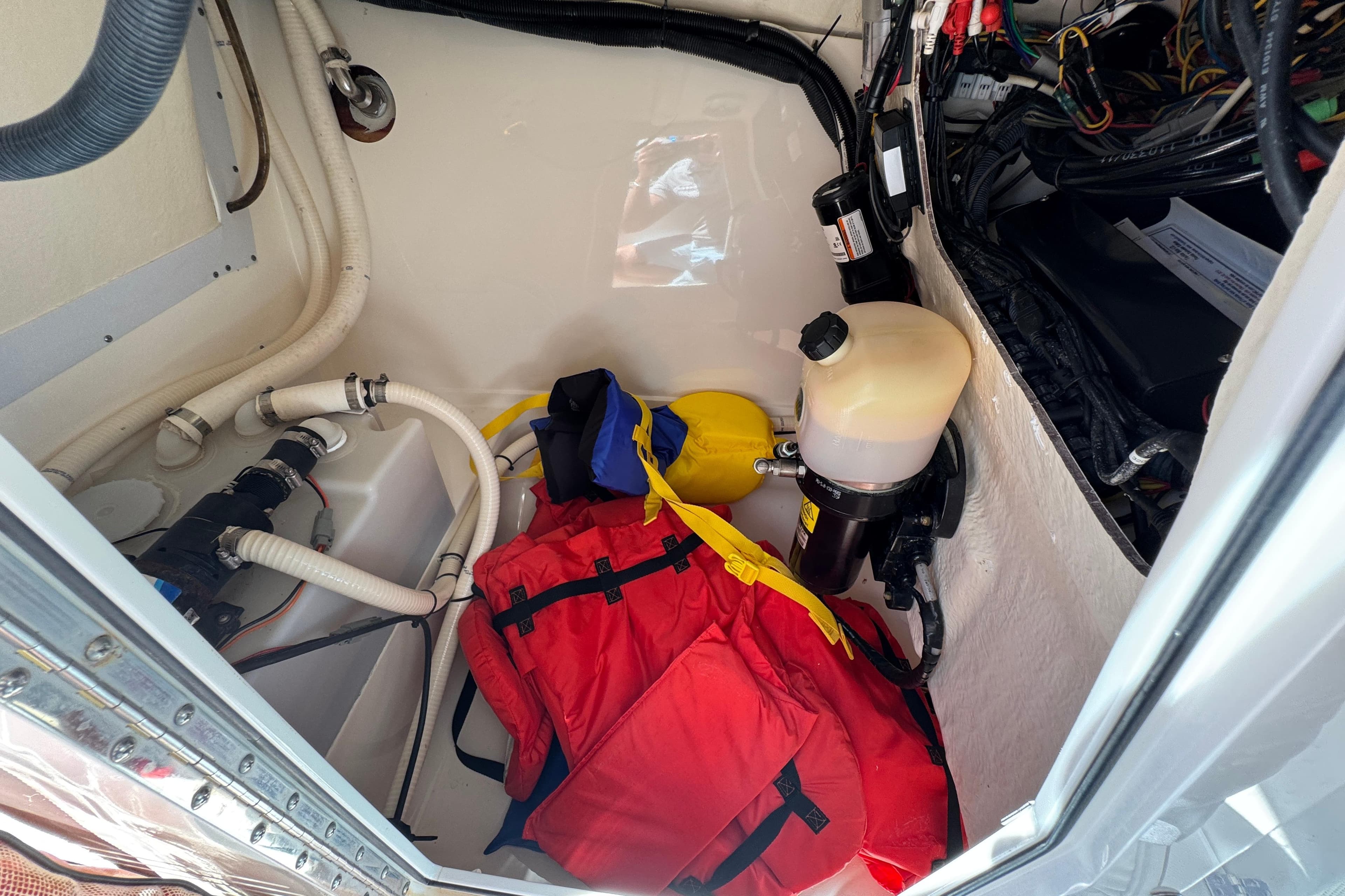 Storage compartment of 2012 Edgewater 245CX Crossover boat with life jackets and equipment.