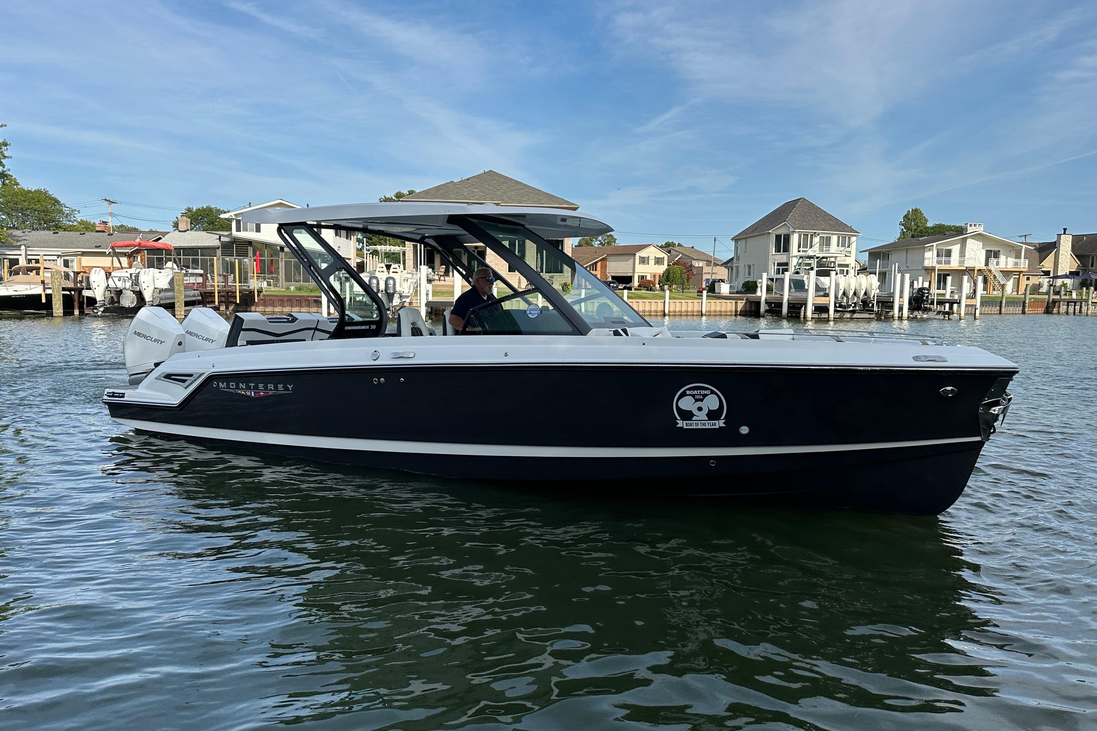2026 Monterey Elite 30 OB boat on calm water, with modern design and twin Mercury engines.