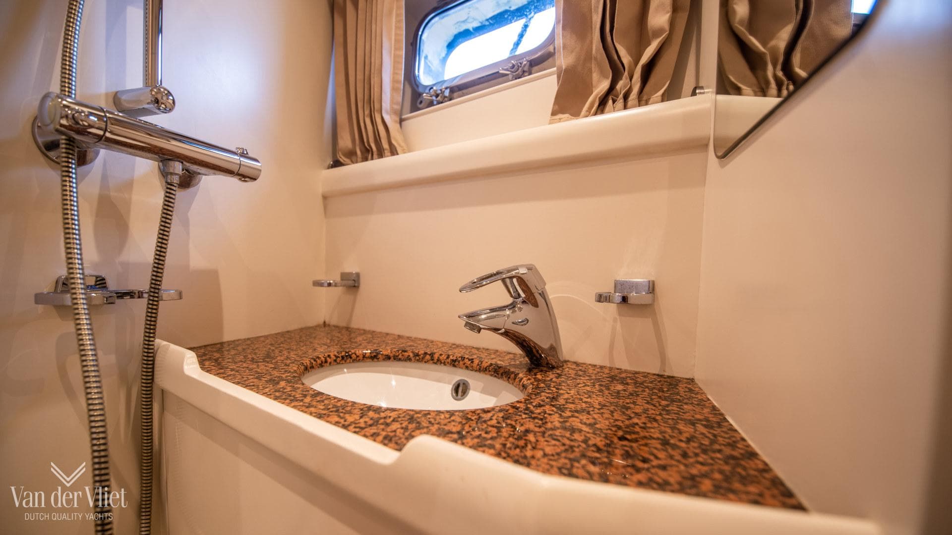 Luxurious bathroom sink in 2008 Nordia 78 yacht with elegant fixtures and granite countertop.