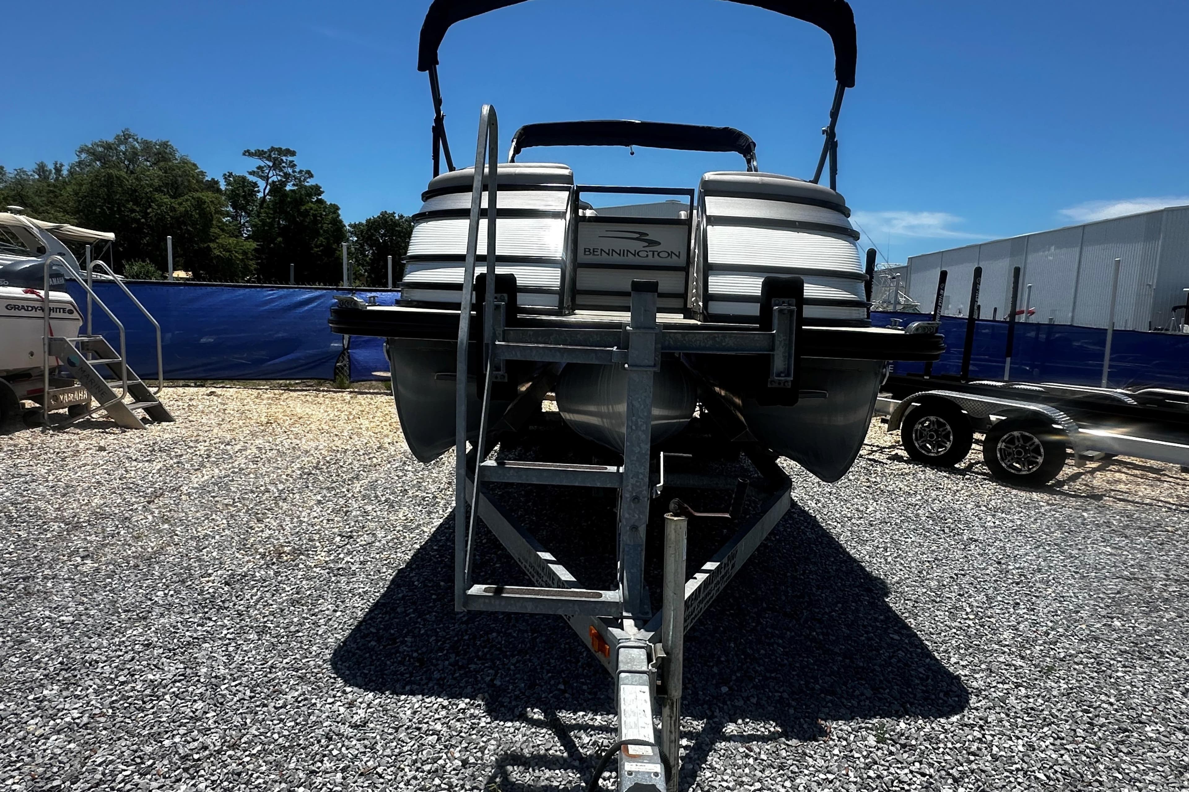 2019 Bennington QX 25 Stern Lounge pontoon boat on trailer, parked outdoors.