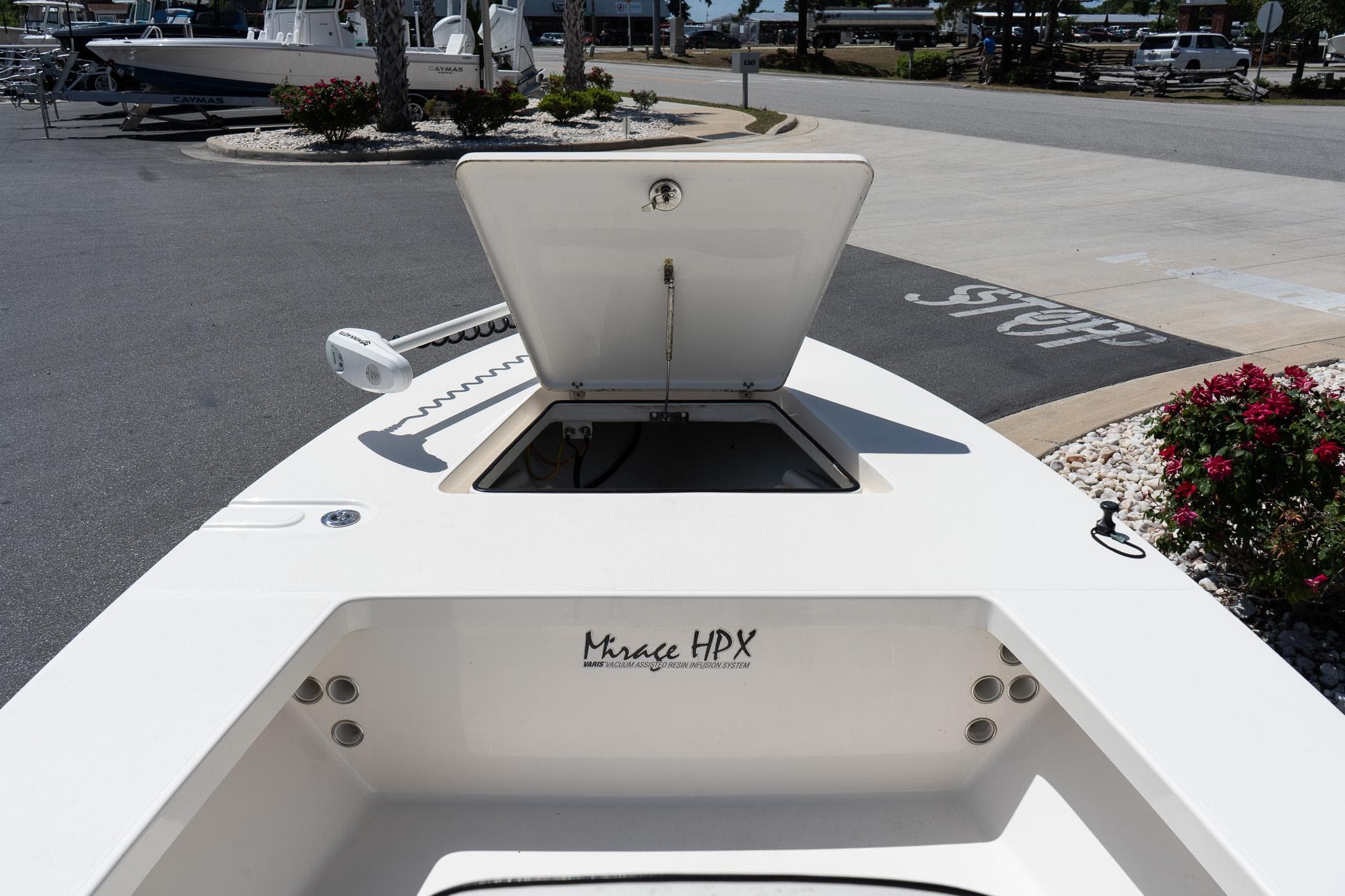 2023 Maverick 18 HPX-V boat with open storage compartment, docked outdoors.