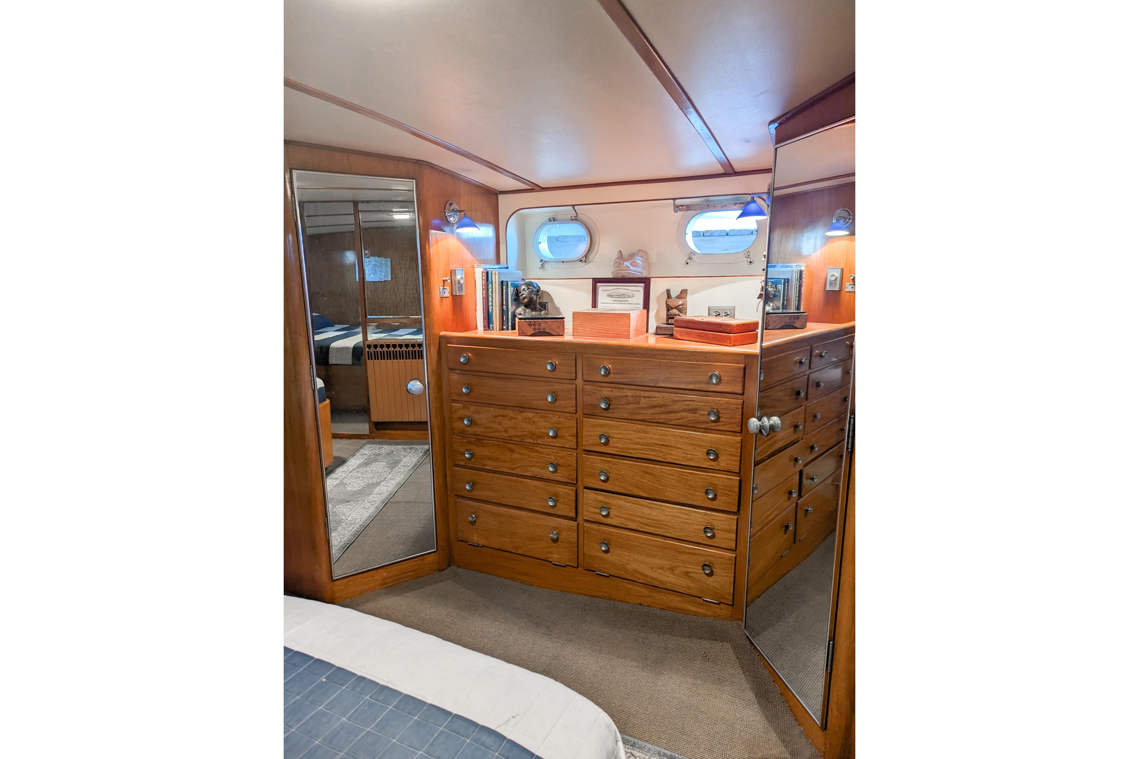 Wooden interior of a 1954 Grebe Sedan with drawers, mirrors, and nautical decor.