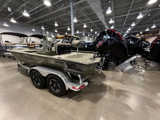 2025 Vexus ACX2000 boat on trailer in showroom, featuring powerful outboard motor.