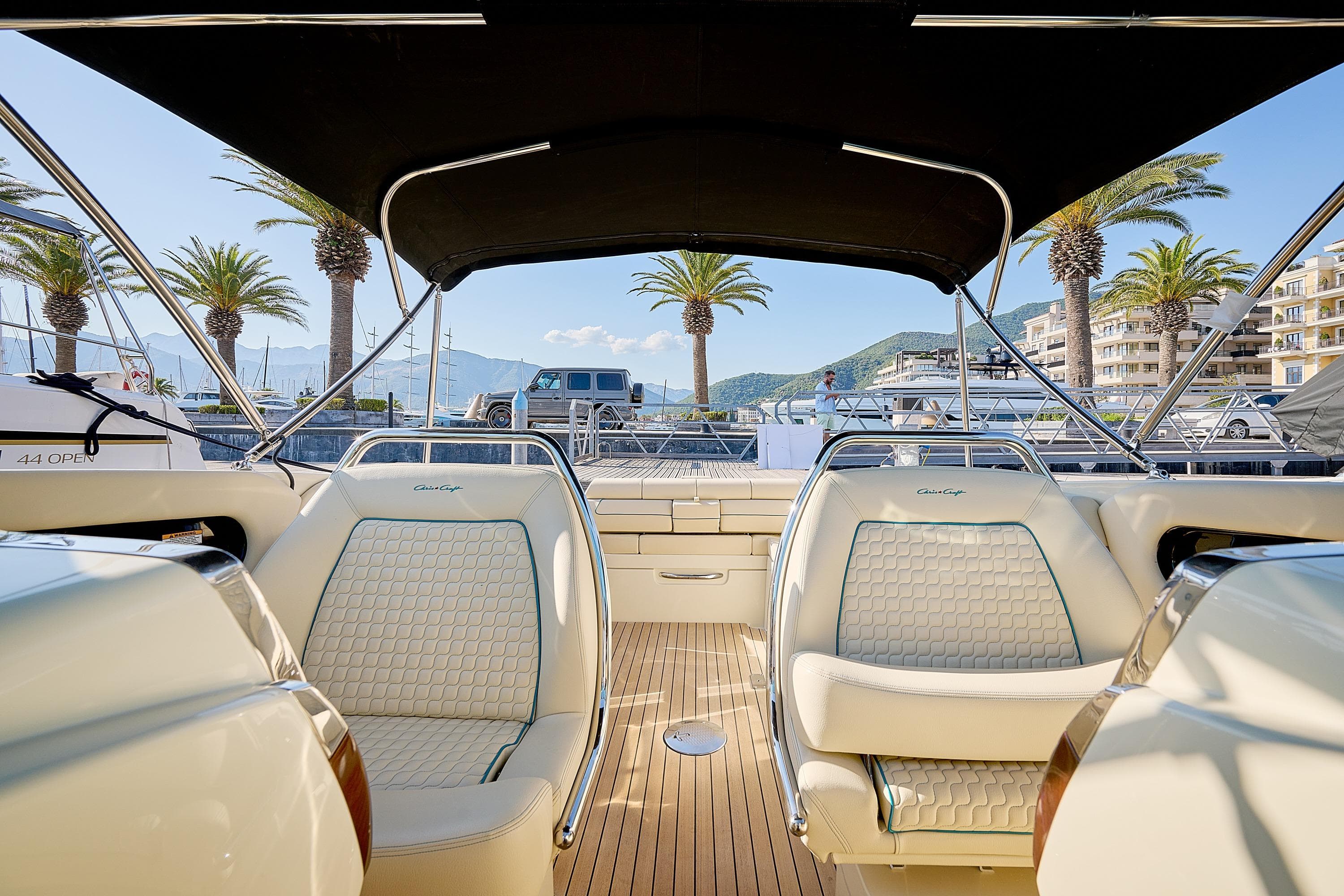 2025 Chris-Craft Launch 31 GT interior with elegant seating and scenic marina backdrop.