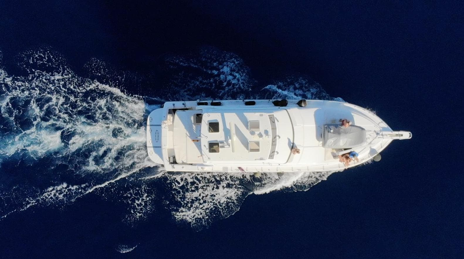Aerial view of 2004 Bertram 510 yacht cruising on deep blue ocean waters.