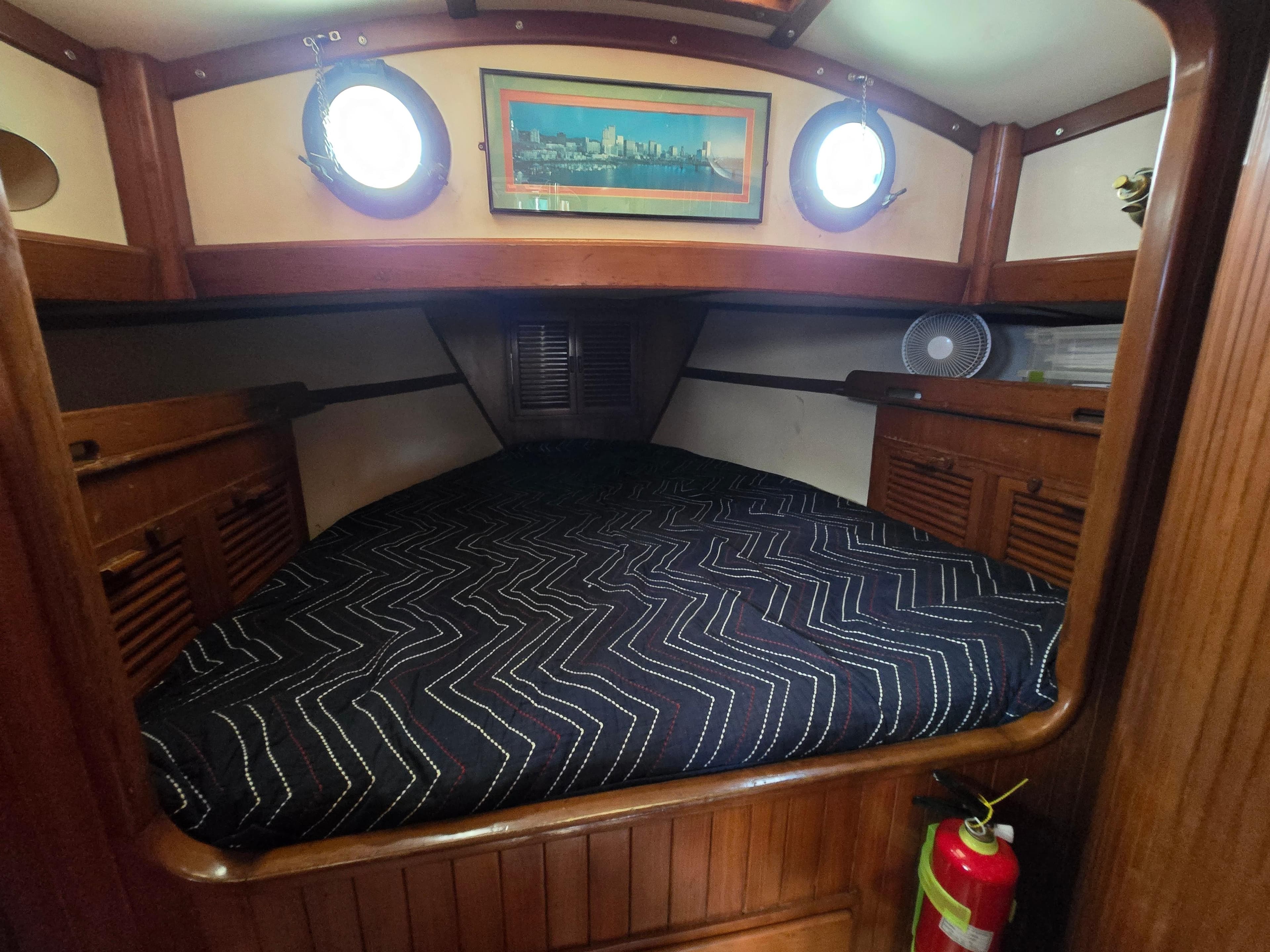 Cozy cabin interior of 1981 Tayana 37 Pilothouse with bed and portholes.