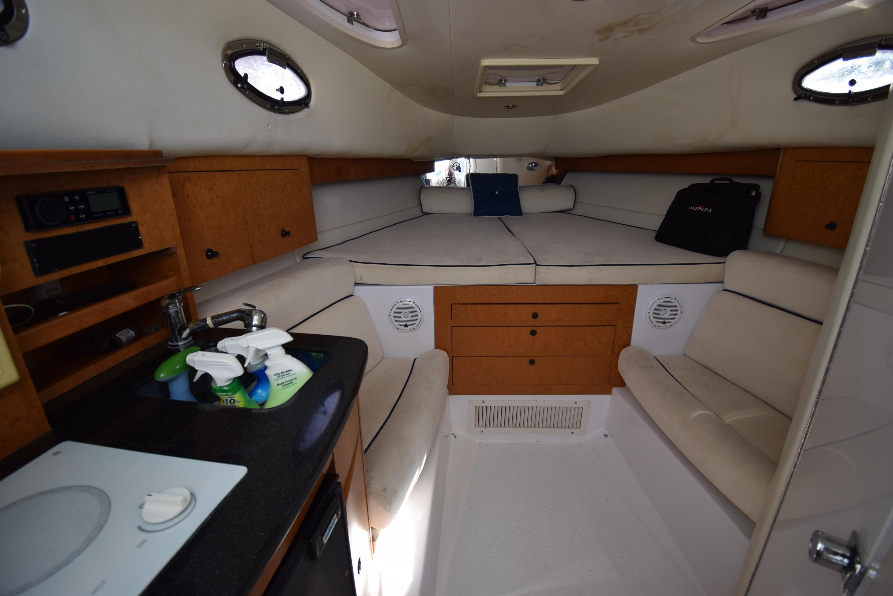 Interior of 2005 Donzi 38 ZSF boat with cozy seating and compact kitchenette.