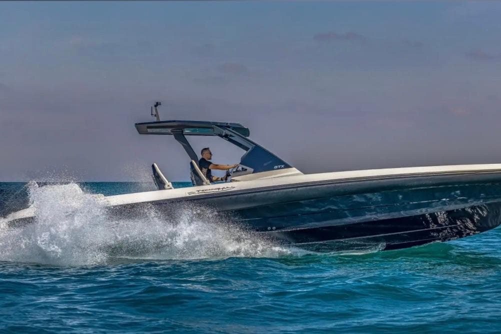 2025 Technohull GTX speedboat cruising on open water, creating splashes.