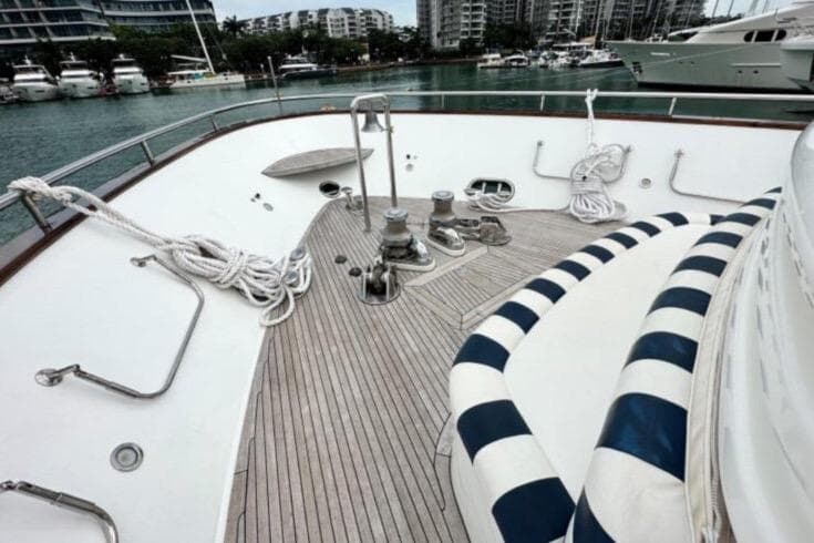 Deck of 2002 Horizon 105 yacht with striped seating and mooring ropes.