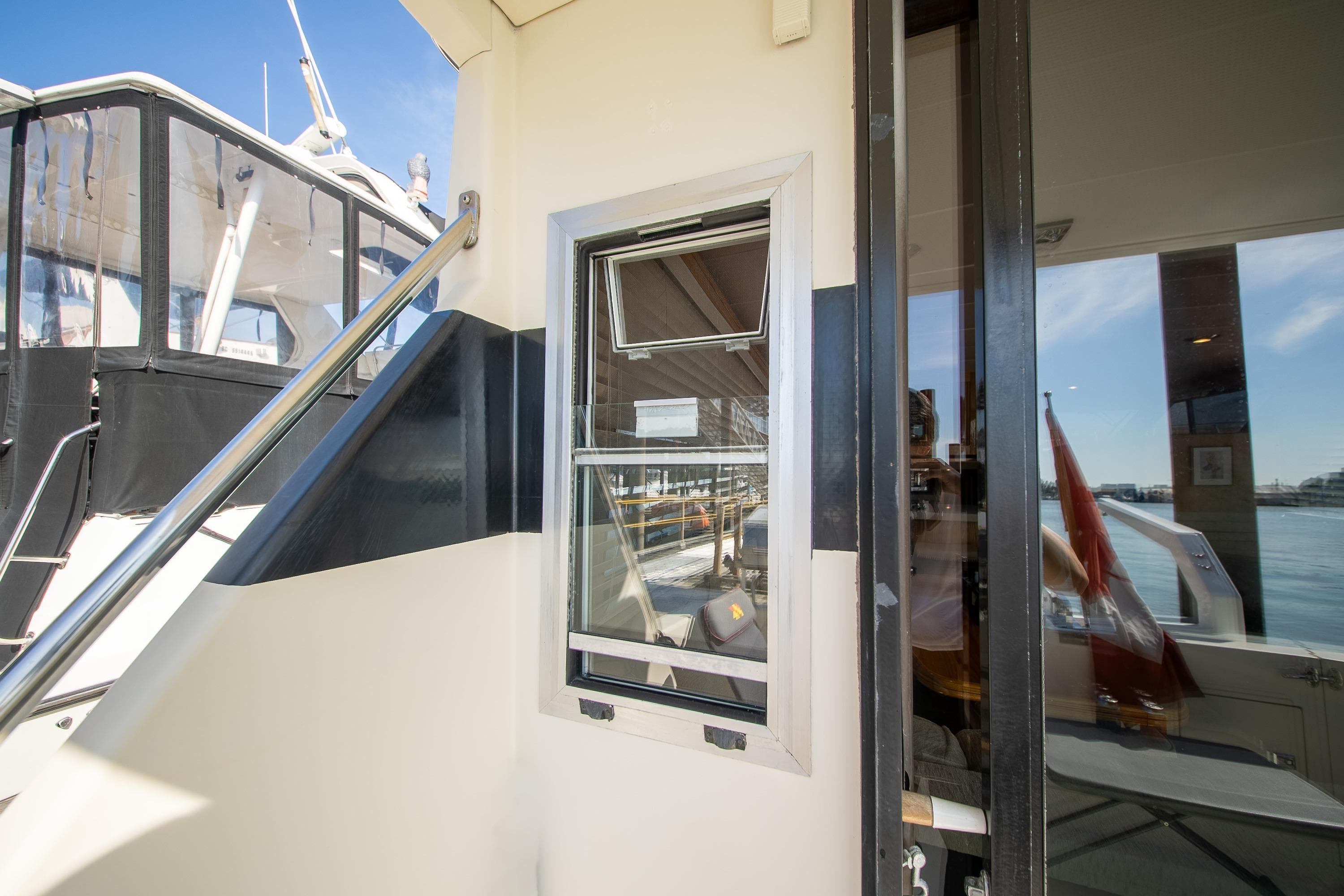 1990 Tollycraft 44 Sedan yacht exterior with window and railing, docked by the water.