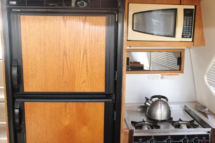 1997 Bayliner 4087 yacht kitchen with fridge, microwave, stove, and kettle.