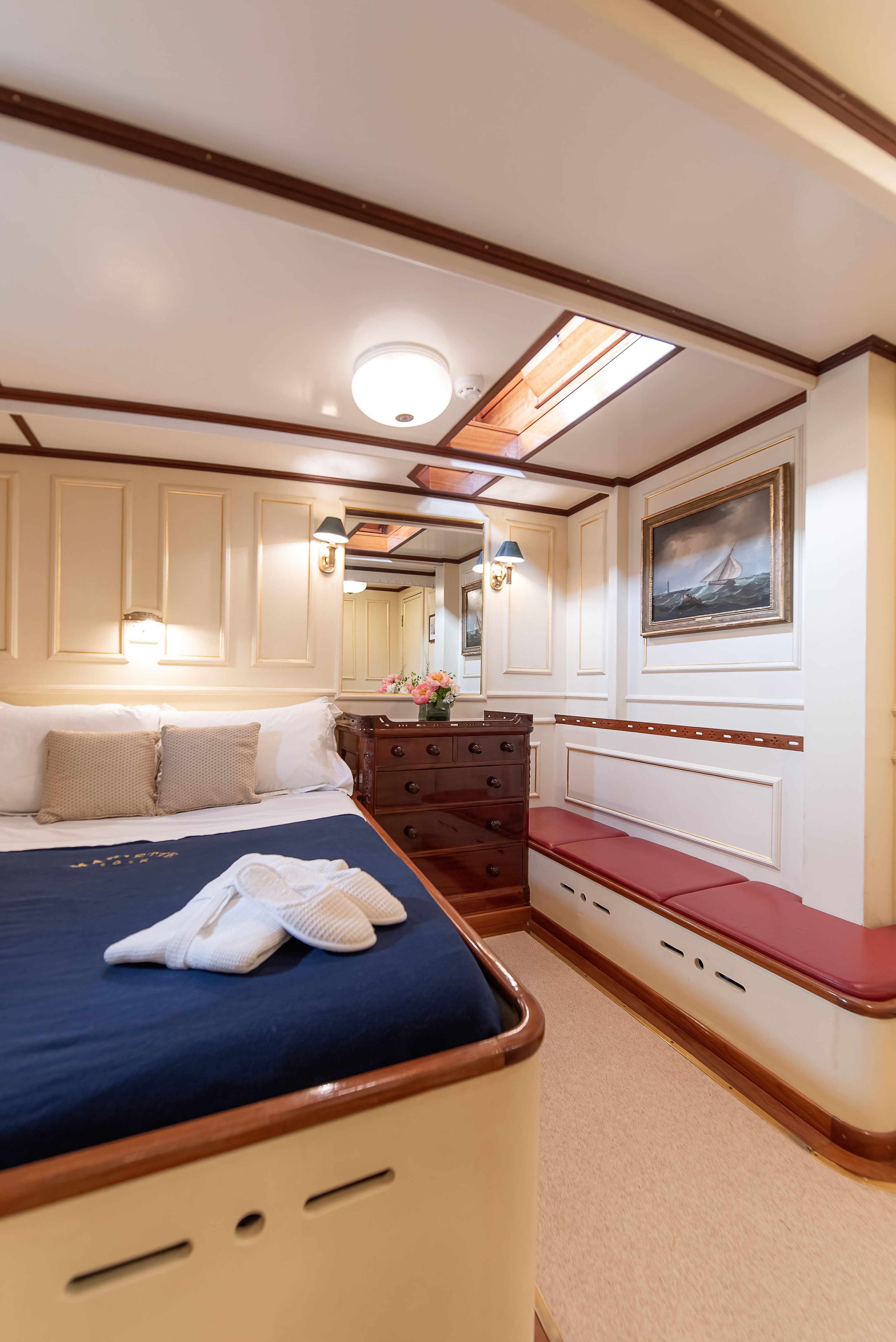 Luxurious cabin interior of 1915 Herreshoff Performance Schooner with elegant wood finishes.