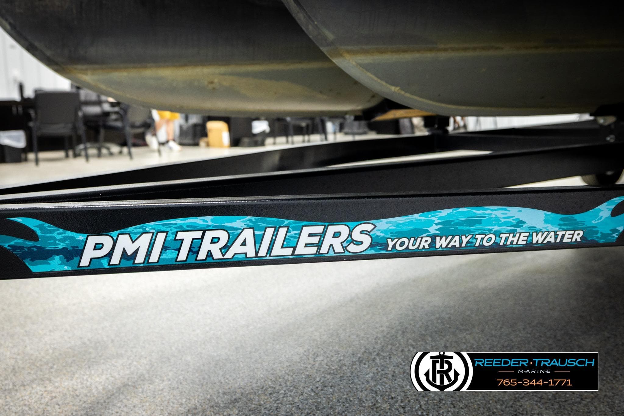 Trailer frame with "PMI Trailers" branding, promoting marine transport solutions.