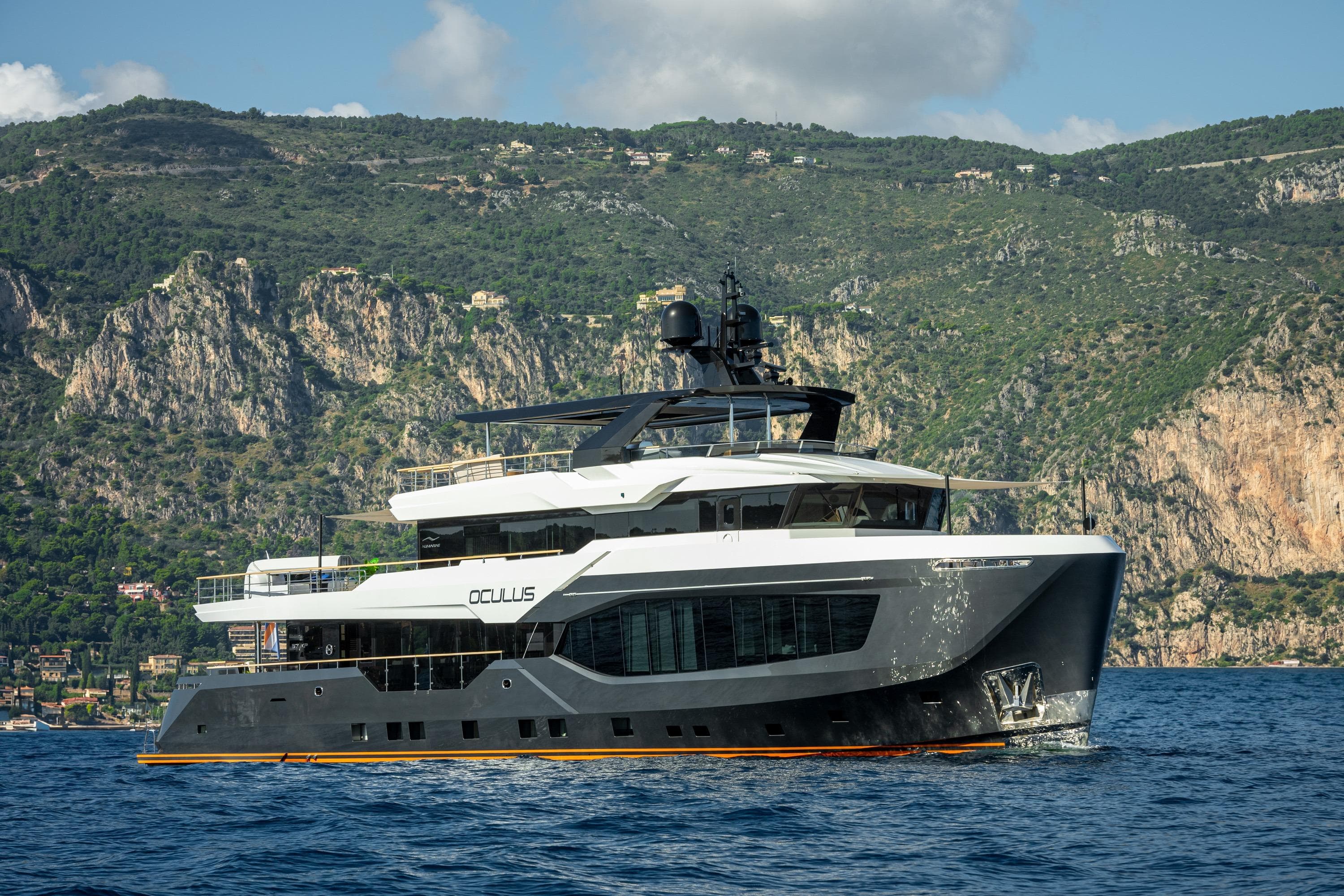 2025 Numarine 37XP yacht cruising near rocky coastline under blue sky.