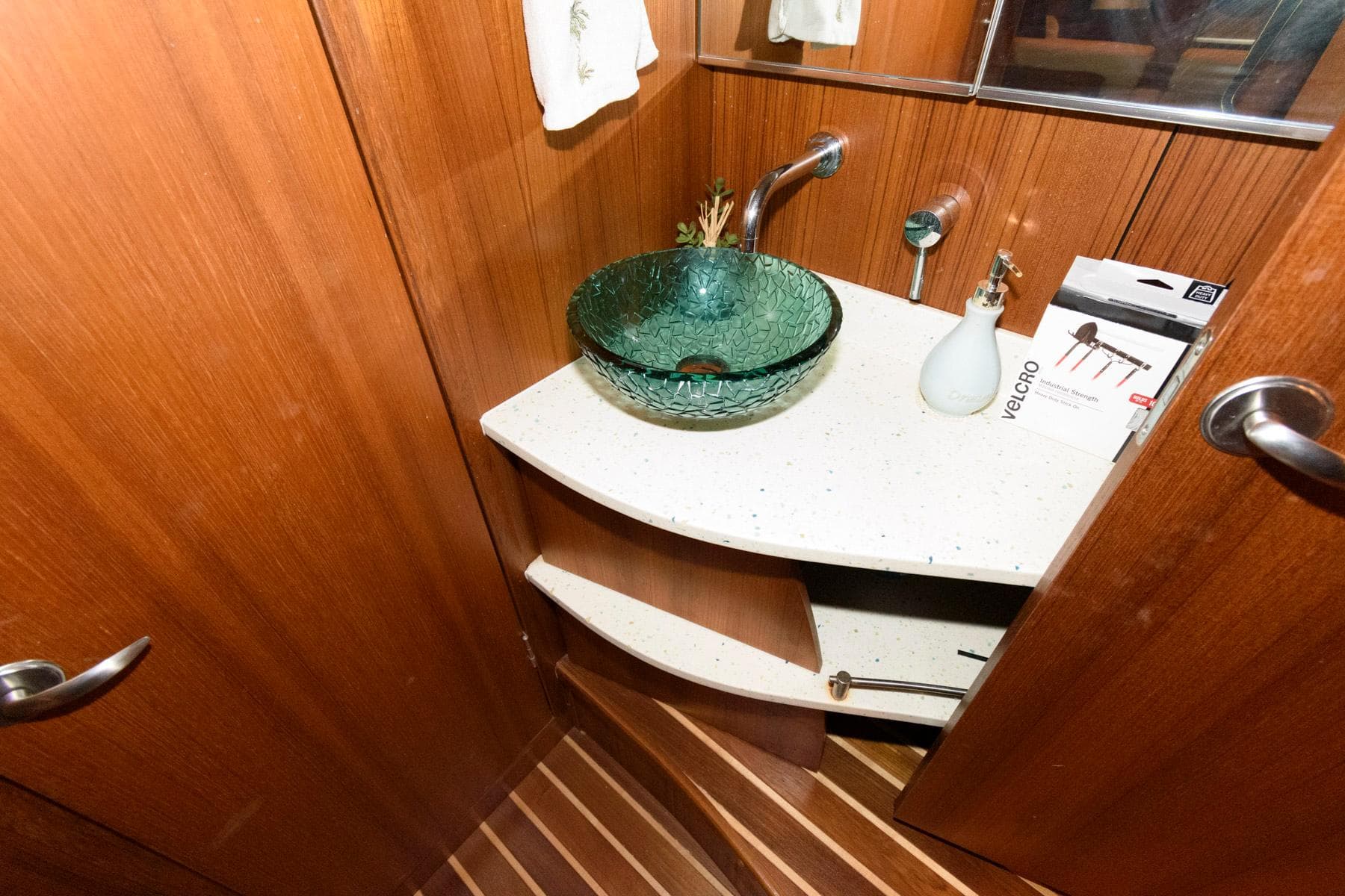 Luxurious 2006 Tiara Yachts 4300 Sovran bathroom with glass sink and wooden cabinetry.