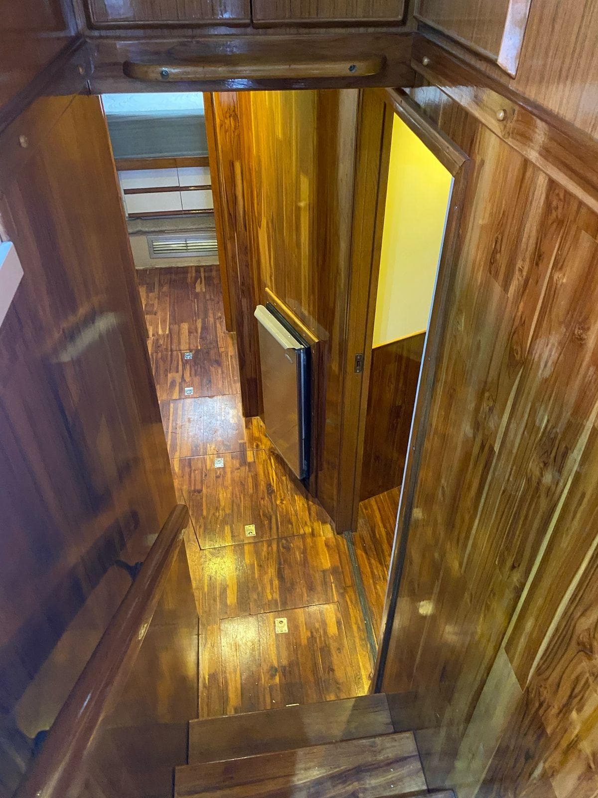 1987 Bertram 50 Convertible interior with polished wood paneling and flooring.