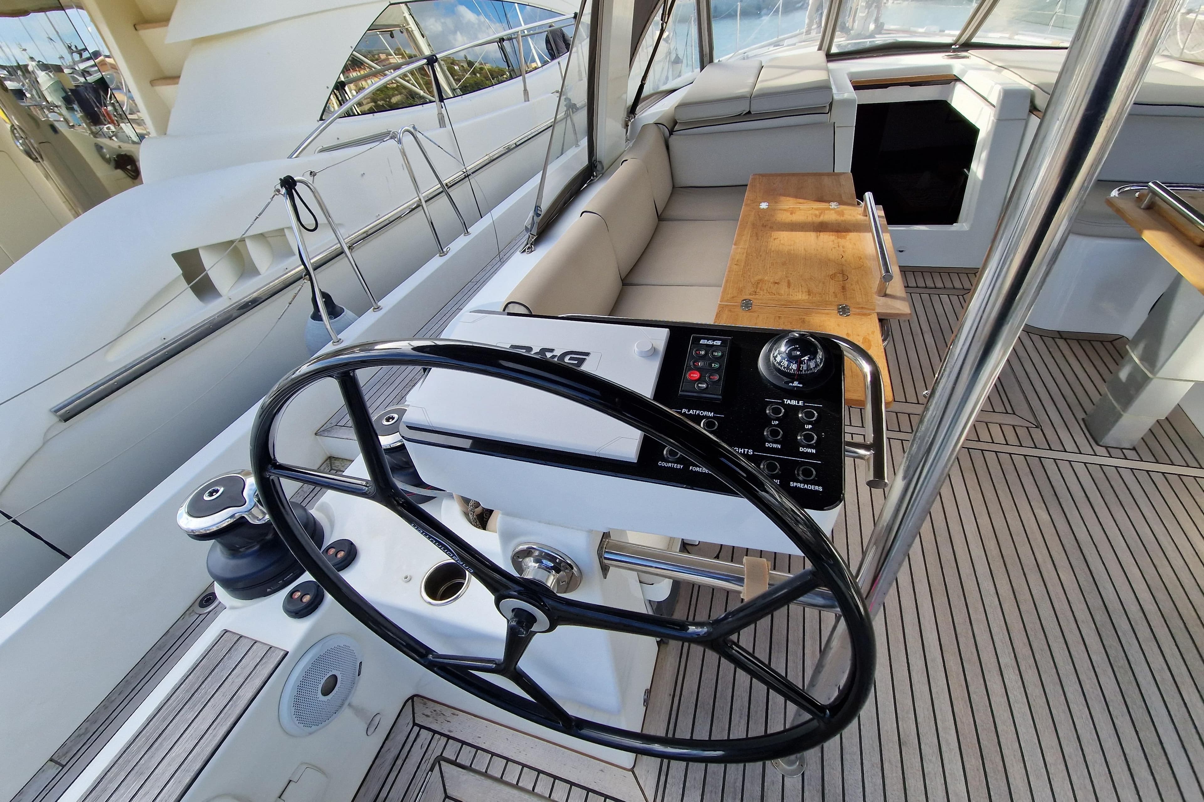 Cockpit of 2022 Beneteau Oceanis Yacht 54 with steering wheel and seating area.