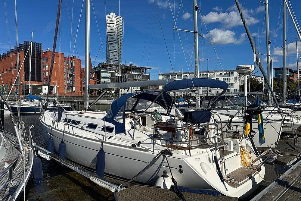 2007 Dufour 455 GL sailboat docked in a marina with urban skyline backdrop.