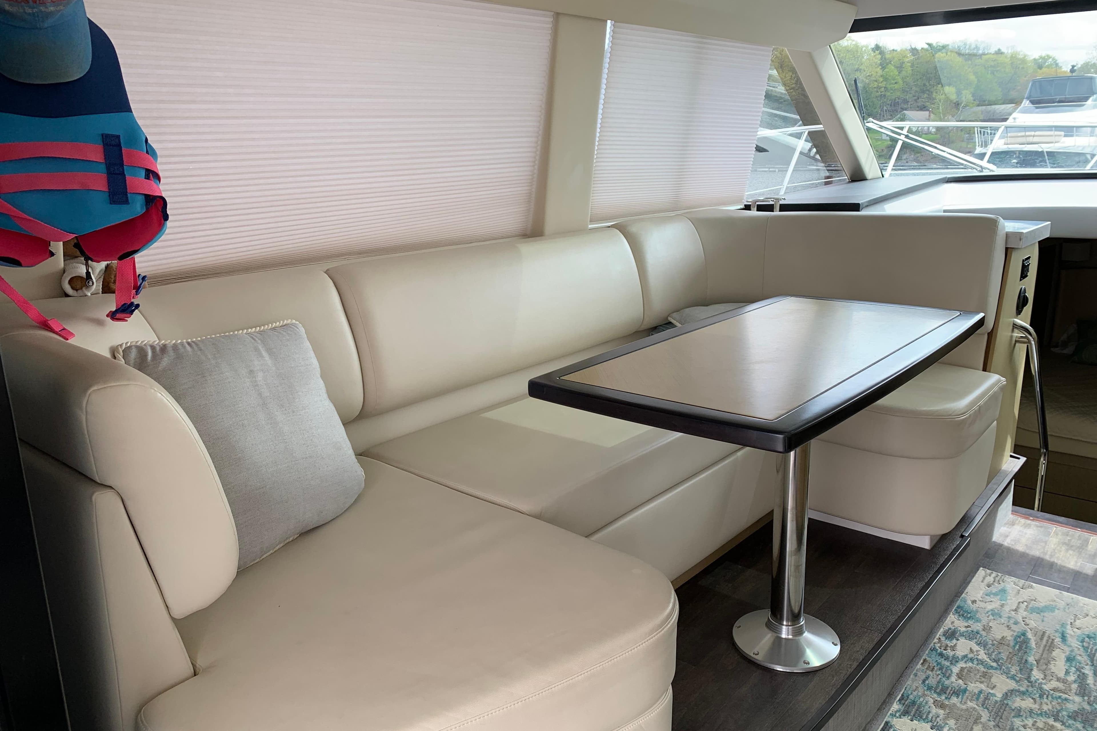 Luxurious interior of 2019 Regal 42 Grande Coupe yacht with elegant seating and table.