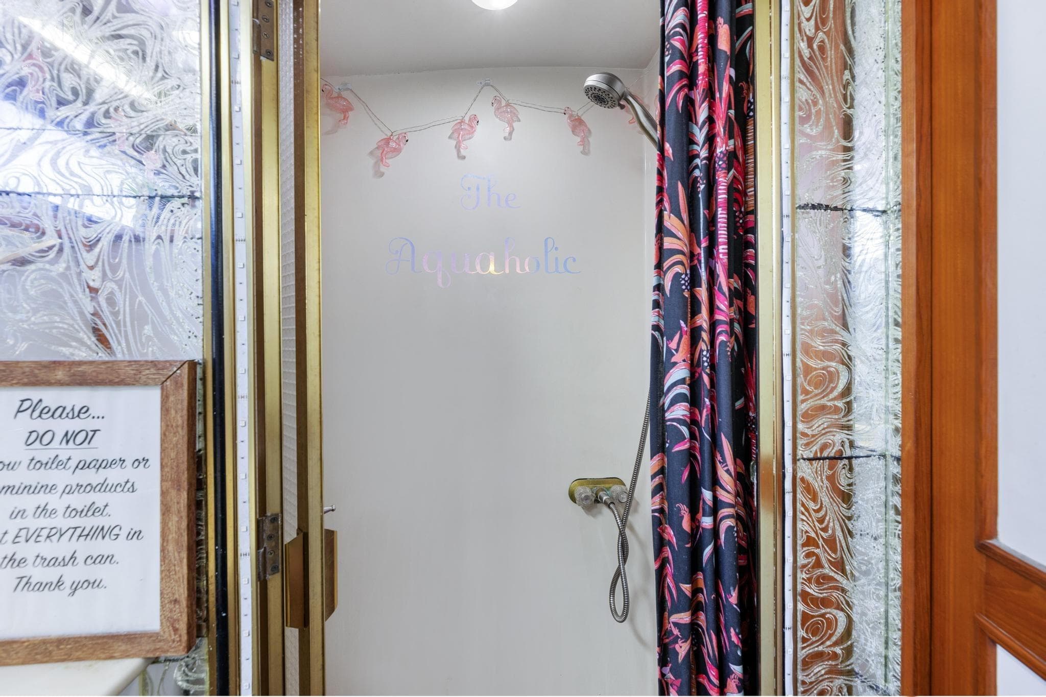 Shower area in 1988 Marine Trader Trawler with decorative curtain and wall sign.