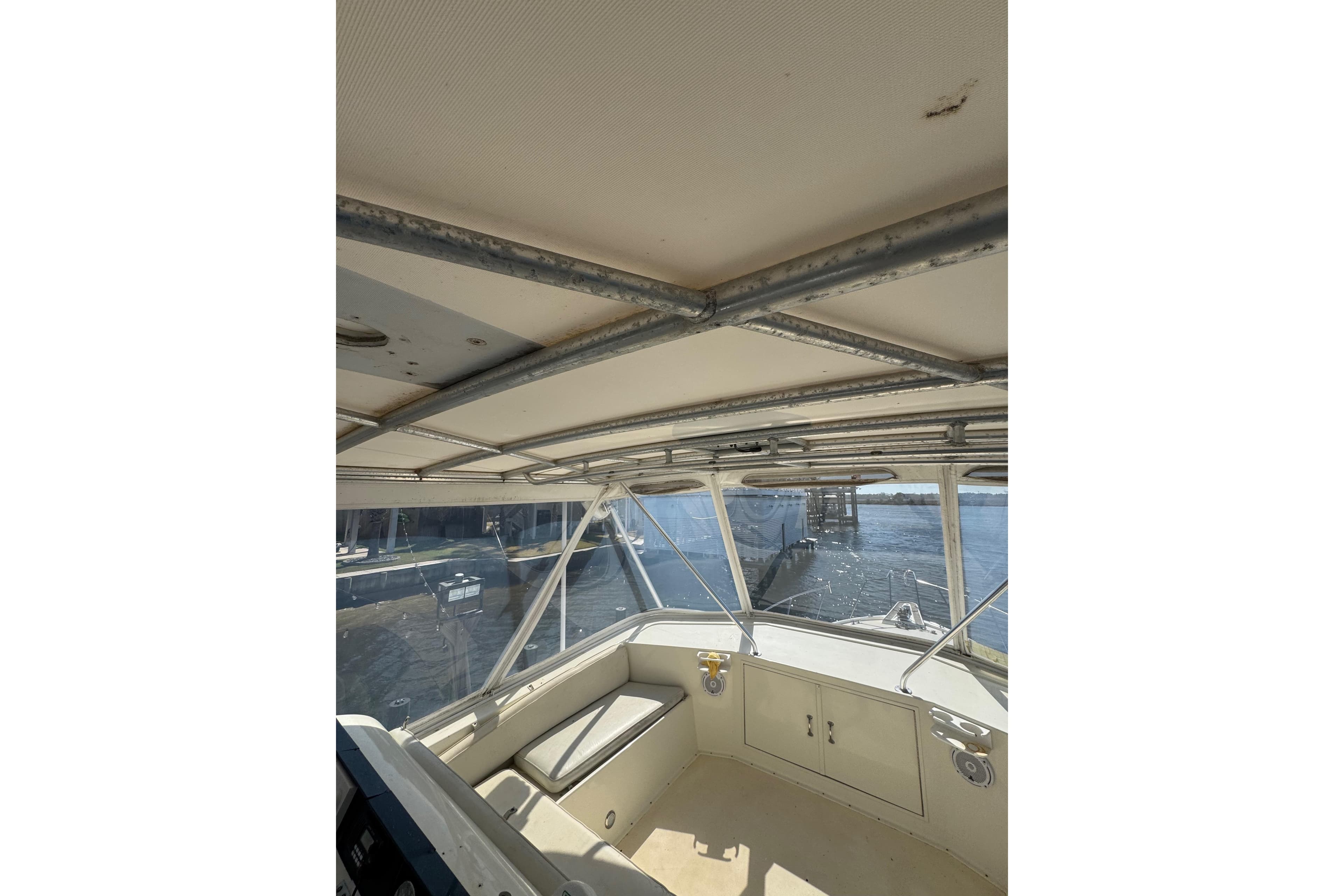 Interior view of 1990 Hatteras 52 Convertible boat with metal framework and windows.